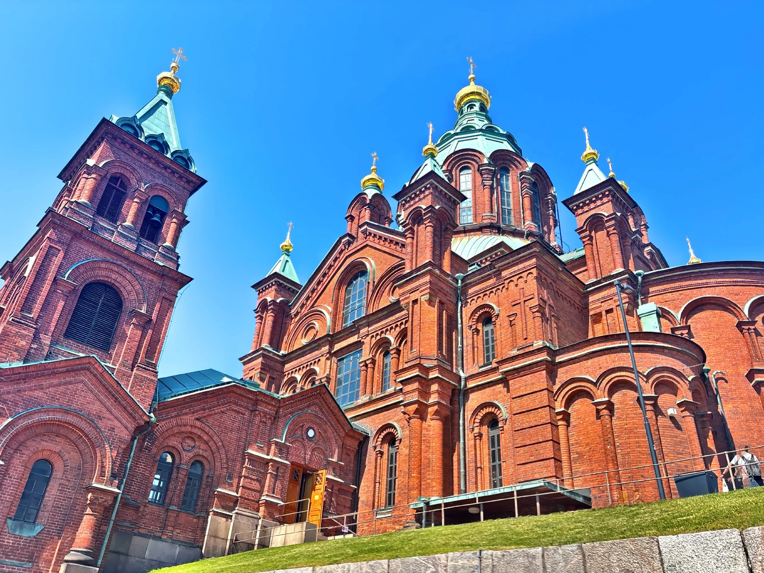  The red-brick cathedral with its Byzantine-Russian style, green domes, and golden cupolas, stands on a hillside in Helsinki’s Katajanokka district. 