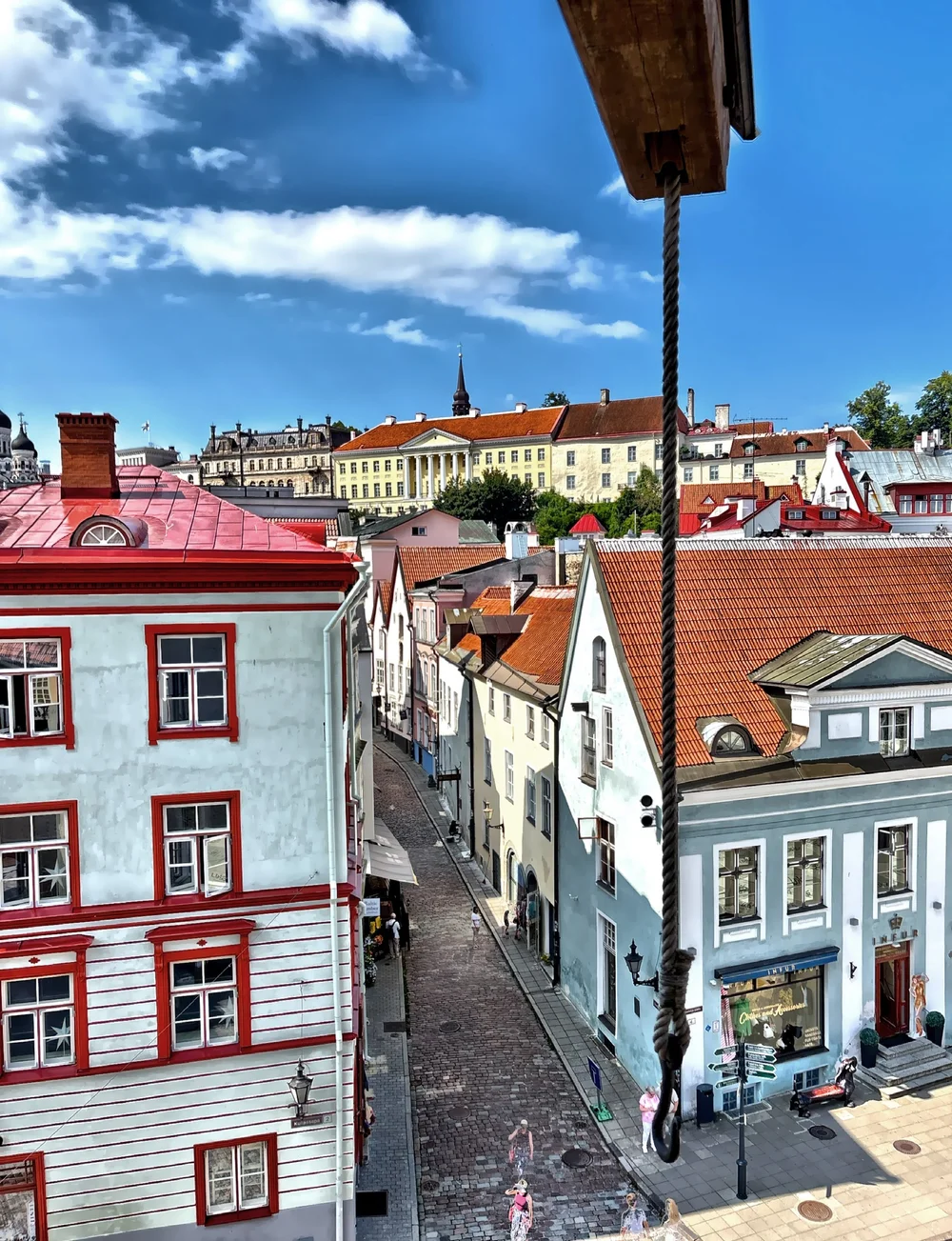  This is a view from the tower of the Old Town Hall Square, a cobblestone plaza surrounded by colorful historic buildings, cafes, and shops. 