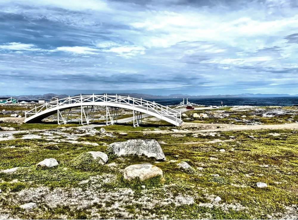  This simple pedestrian bridge spanning over the road leading to Nuuk Cemetery wasn’t built for convenience—it was constructed with purpose and respect.  Locals say it was designed specifically to allow funeral processions to pass peacefully overhead