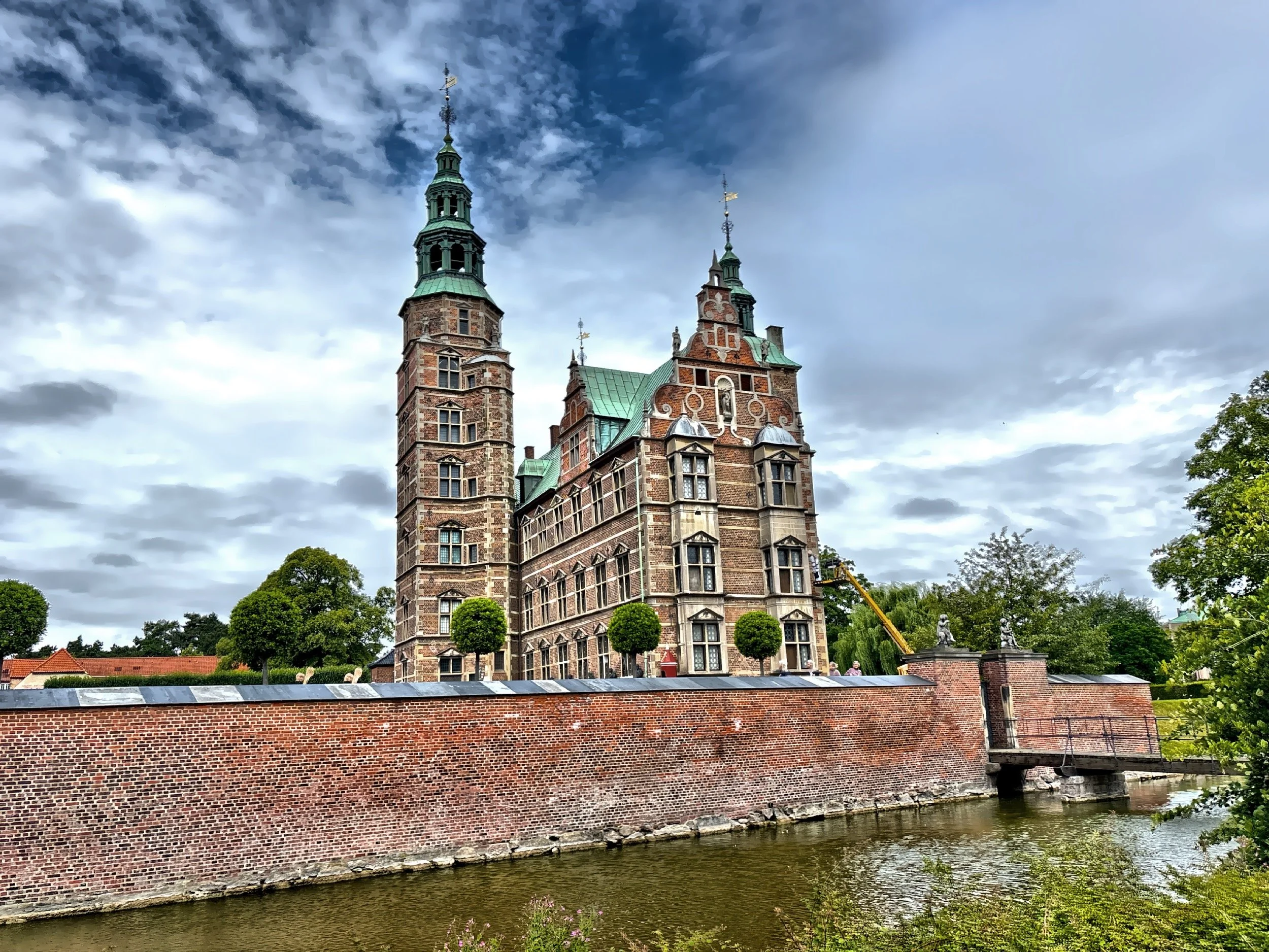  The castle facade features symmetry with red brick with sandstone decorations, stepped gables, and copper-roofed towers. 