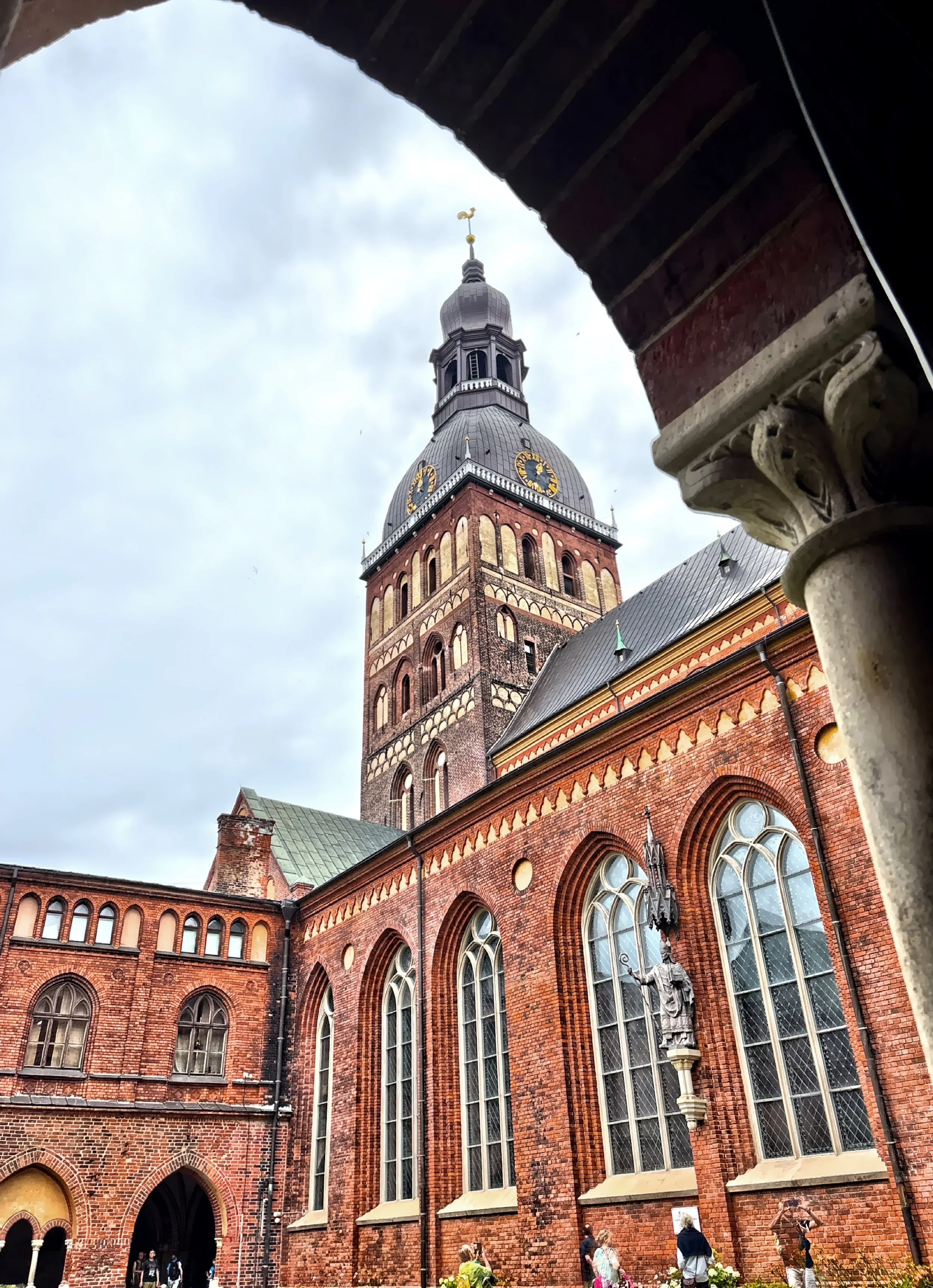  Riga Cathedral is massive and unmistakable with its distinctive red-brick façade and tall weather vane-topped tower.   