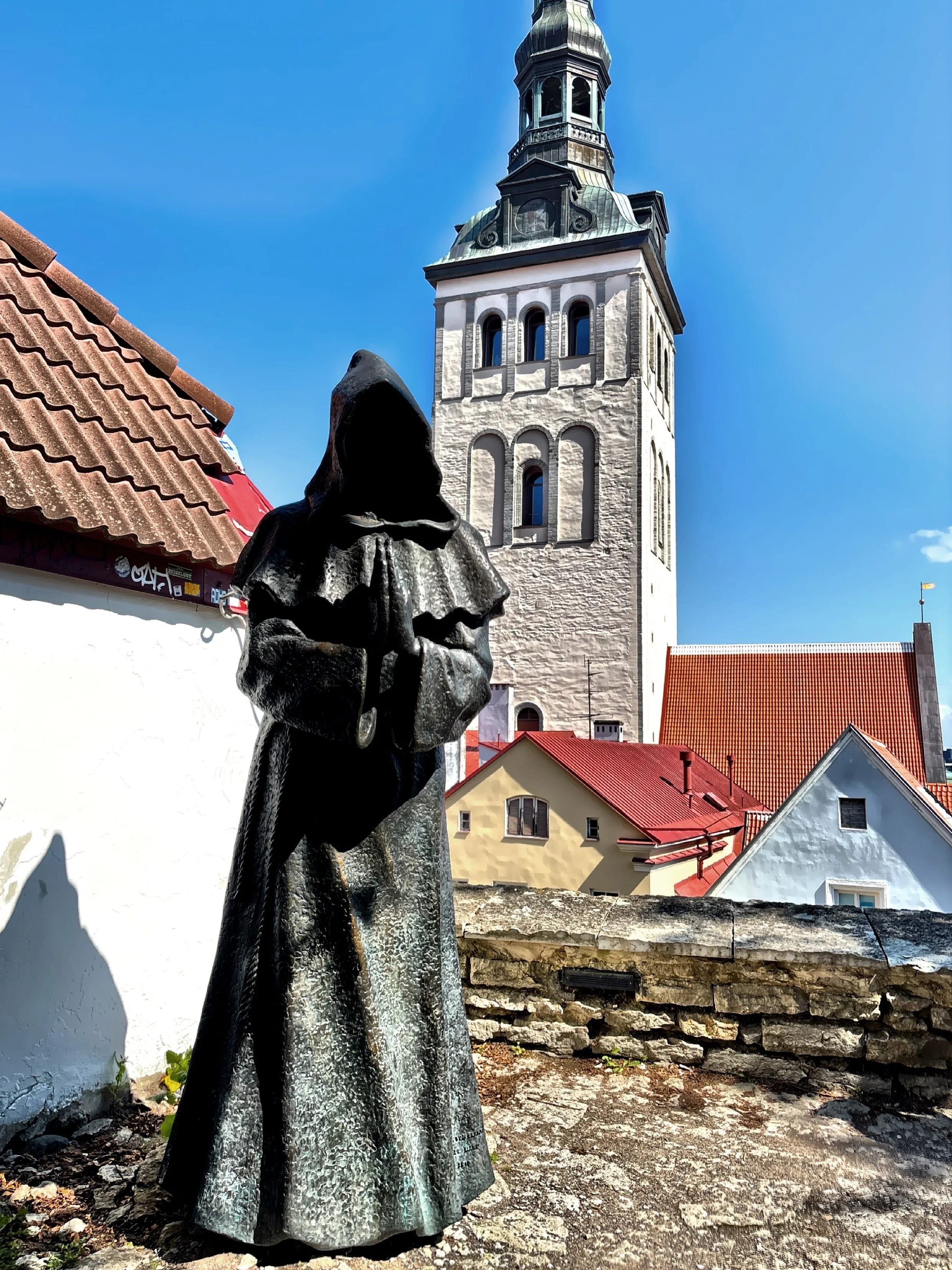  The monk sculpture is a part of a group of three, located in the Danish King’s Garden.  The tower of St Nicholas Church is visible in the background. 