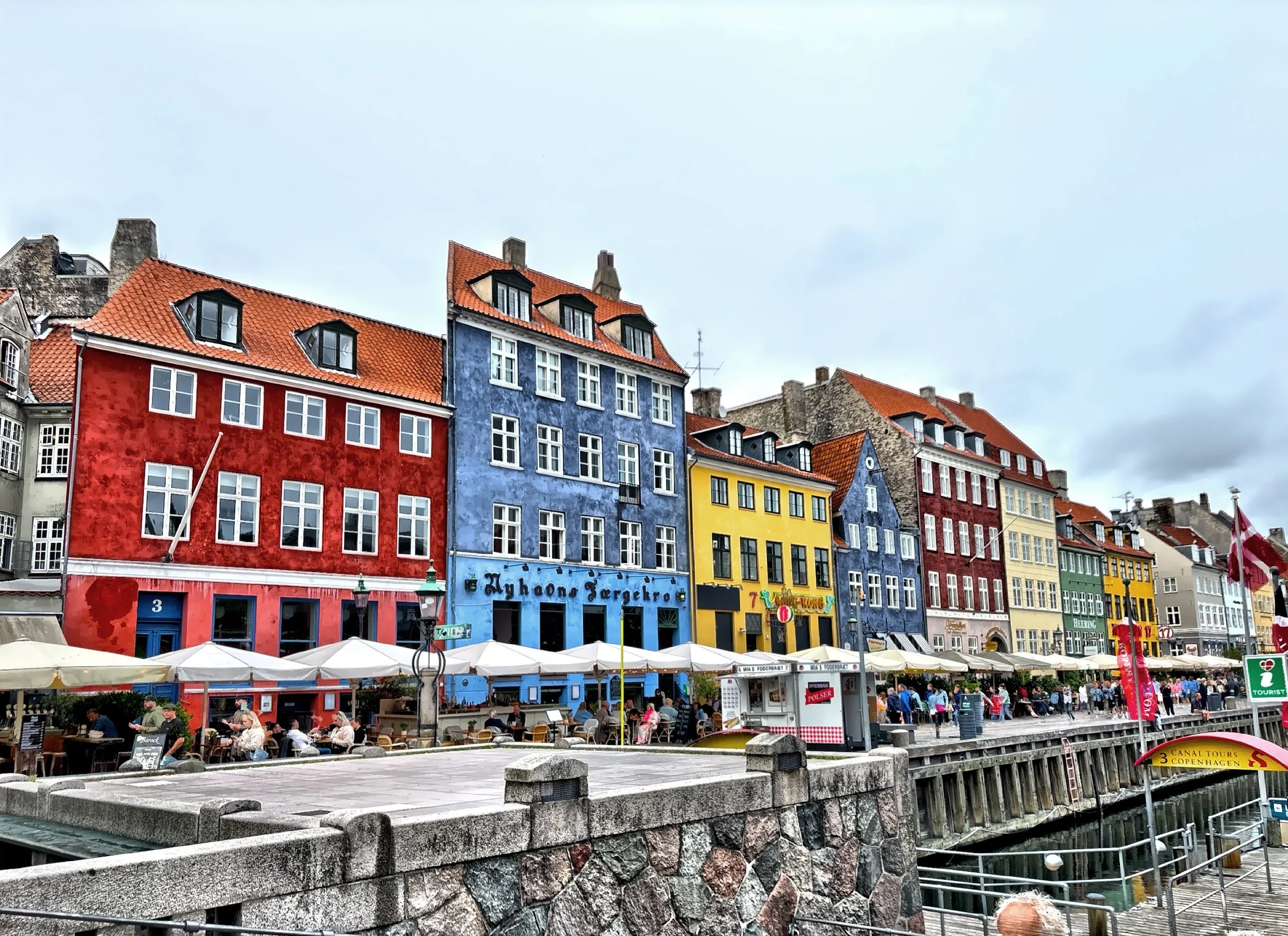  Once a bustling 17th-century commercial port, Nyhavn is now a vibrant, postcard-perfect waterfront area.  Originally constructed to allow ships to bring cargo directly into the city center, it quickly became a hub of sailors, pubs, and trade.   