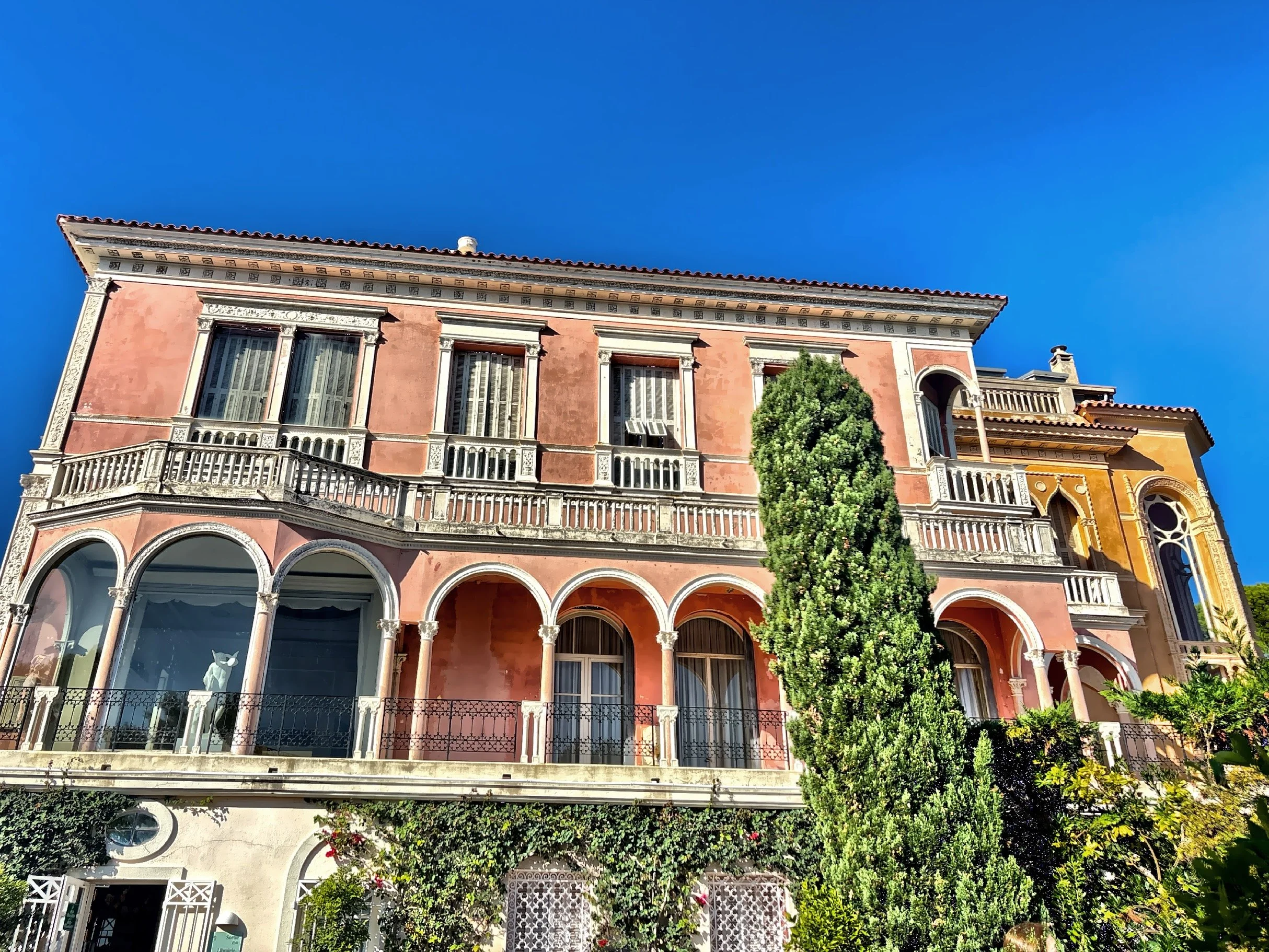  The pink facade of the mansion appears like a confection set against the blue sky. 