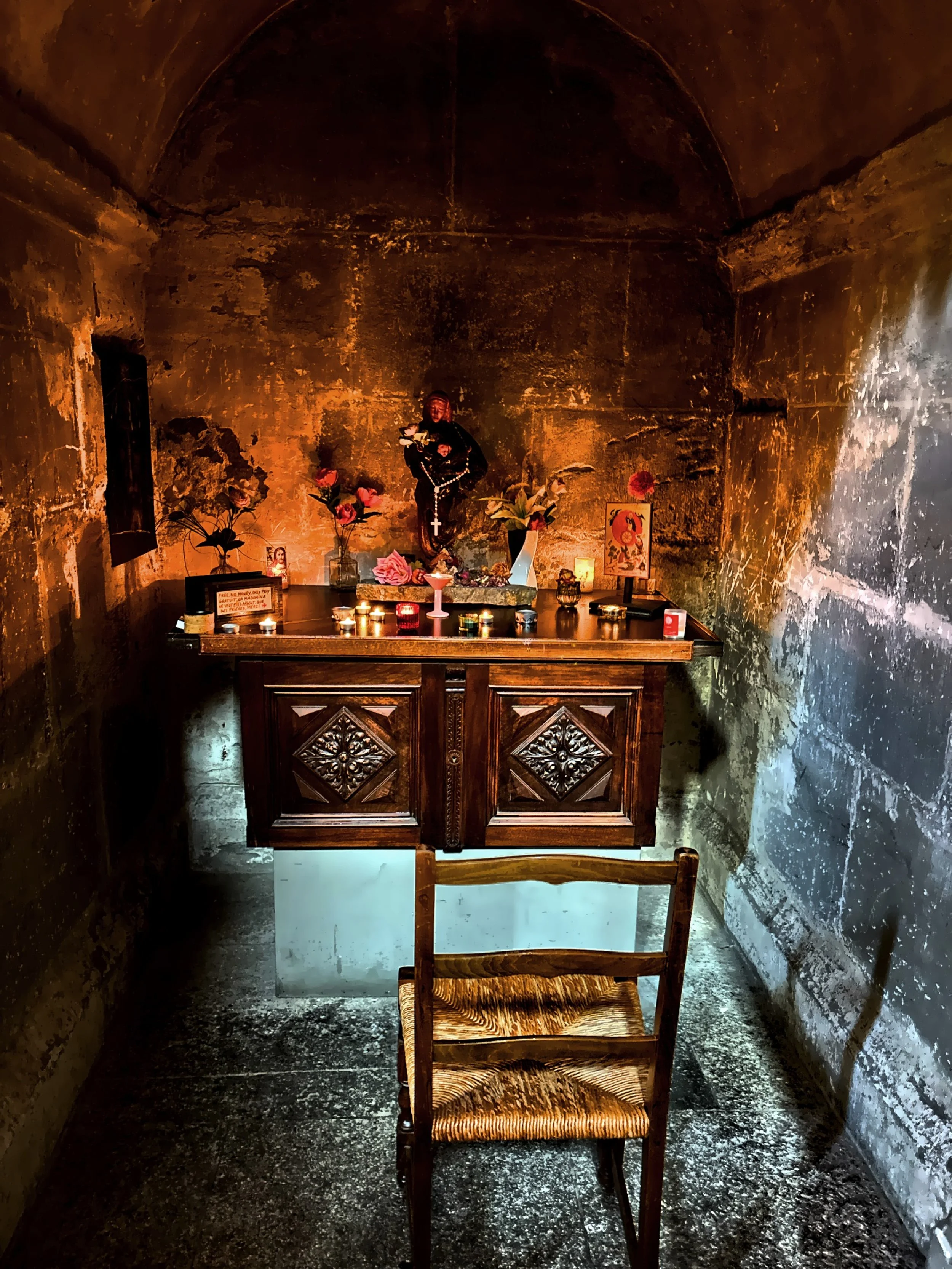  A small, candlelit alter decorated with flowers and candles. 