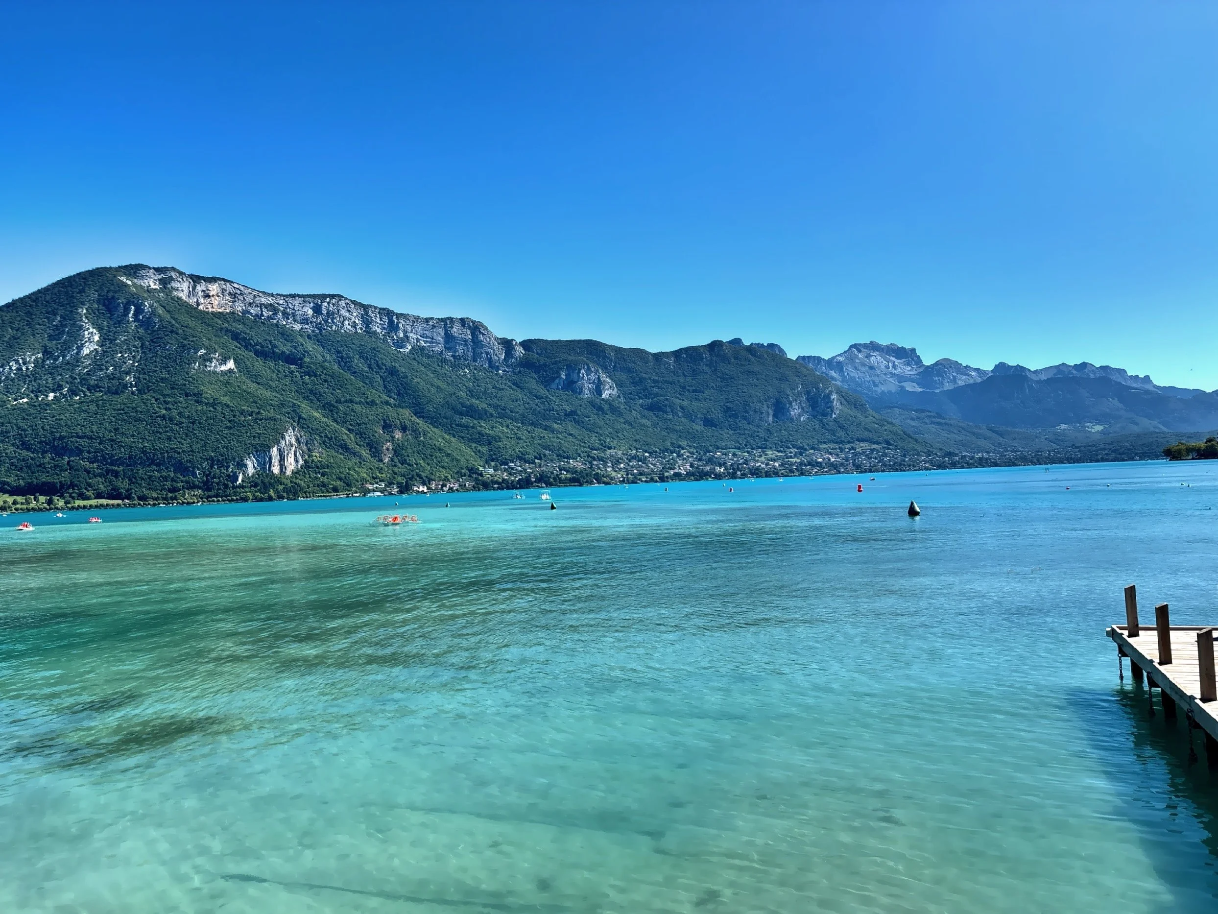  The city is framed by the turquoise waters of Lake Annecy, reflecting the surrounding Alpine peaks  