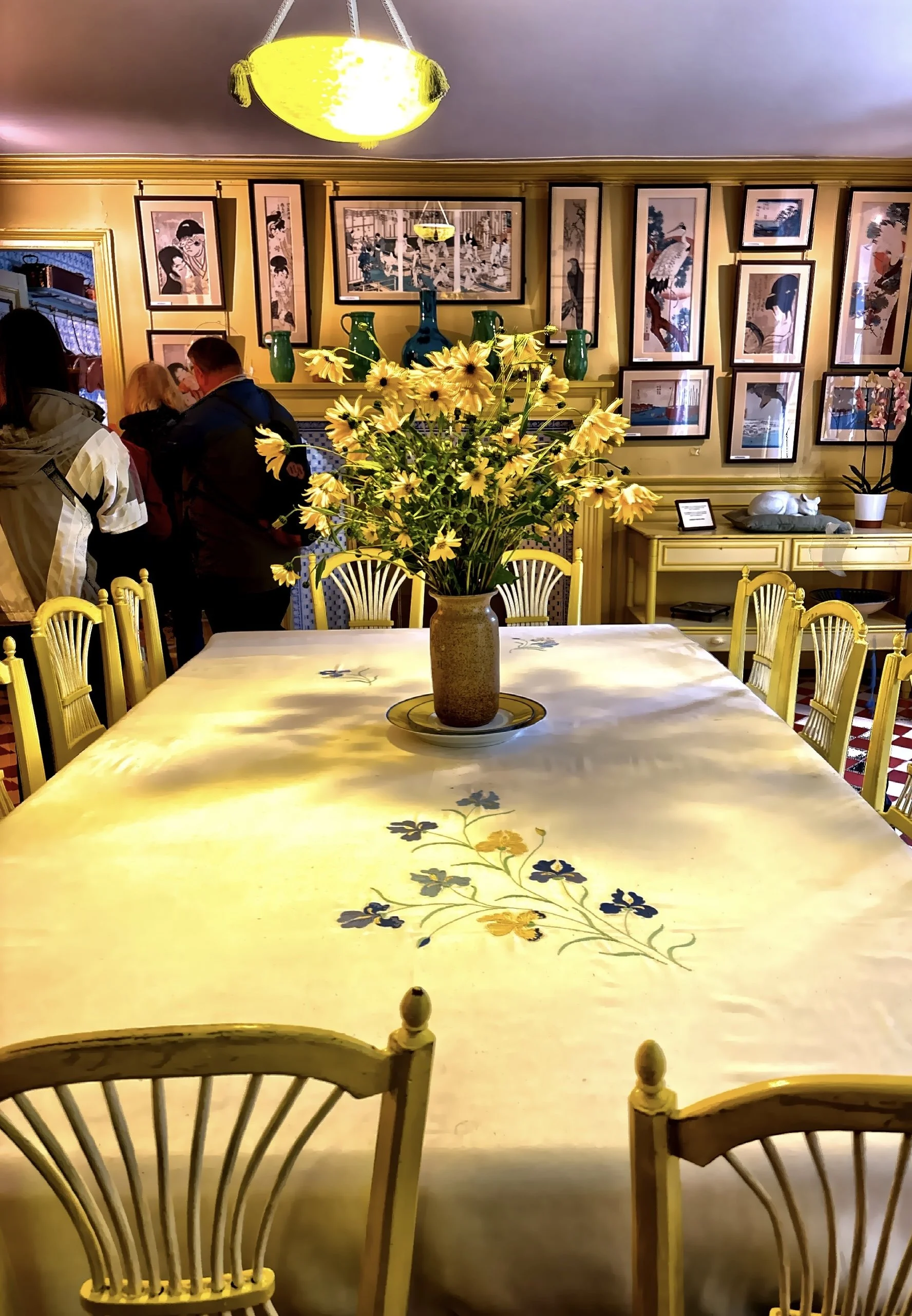  The yellow dining room — walls, chairs, and even dishware in a cheerful sunflower hue. 