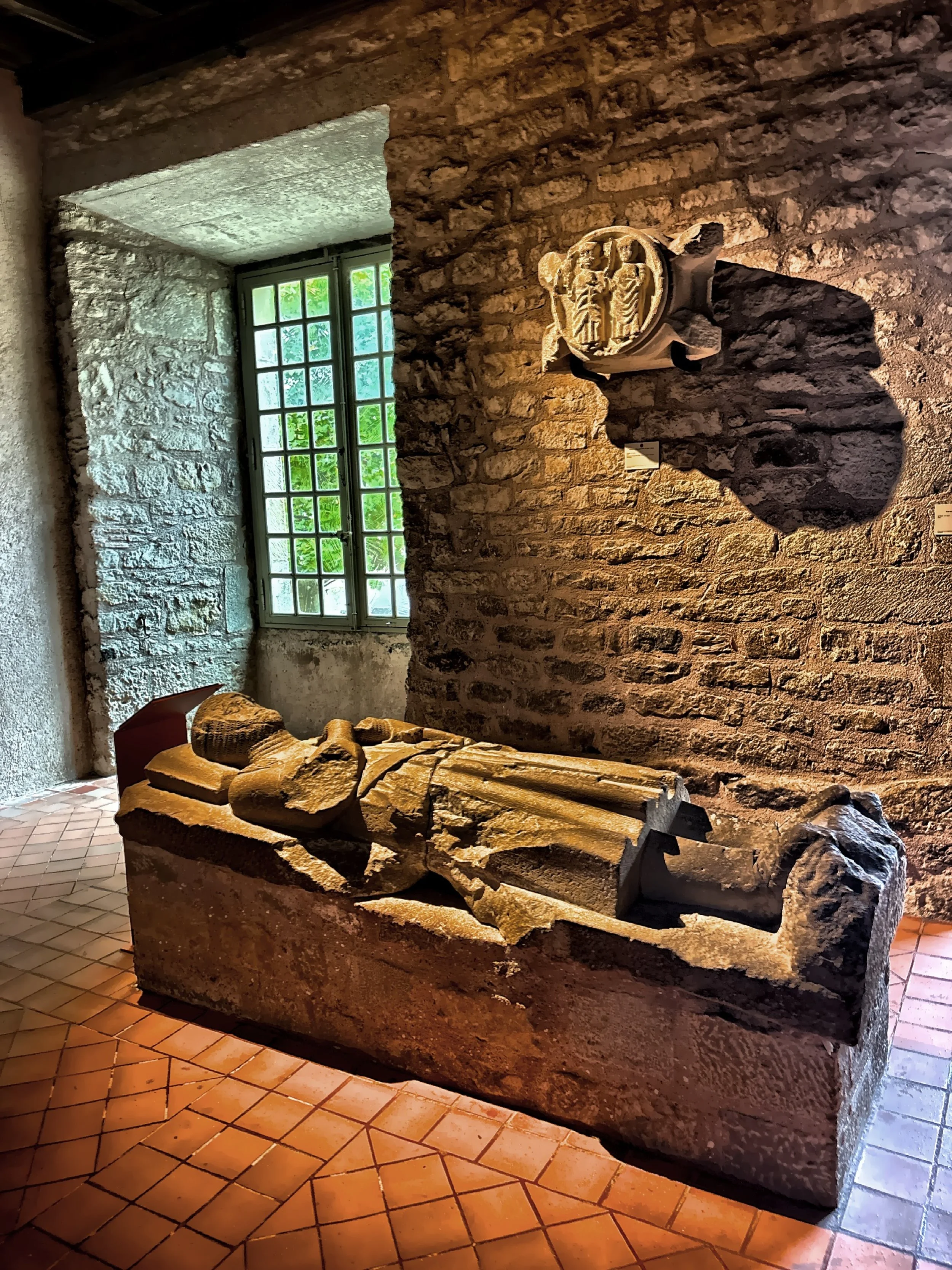  A stone effigy tomb carving and round carved roundel.  