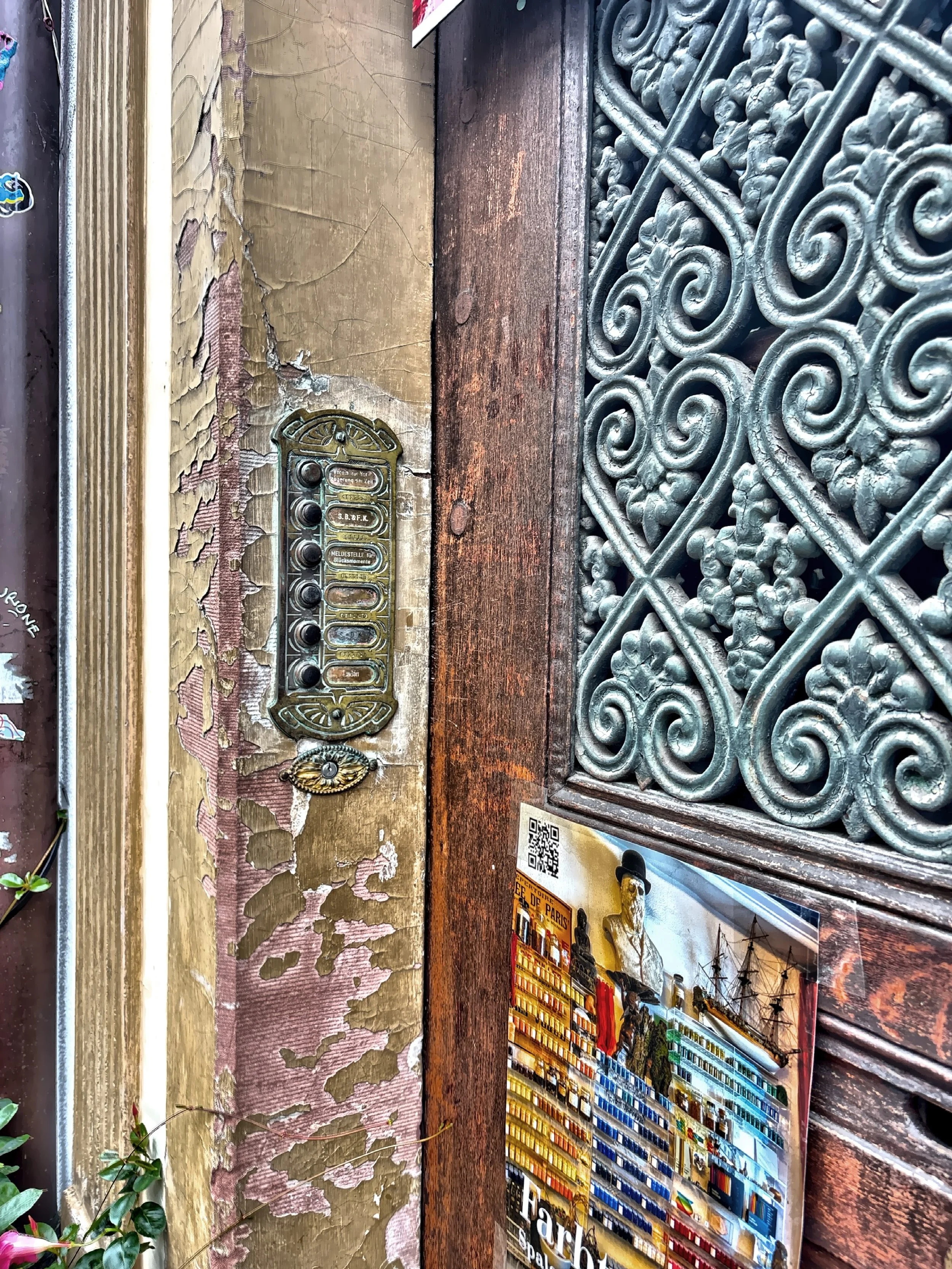  An antique doorbell panel and decorative door metal grille. 