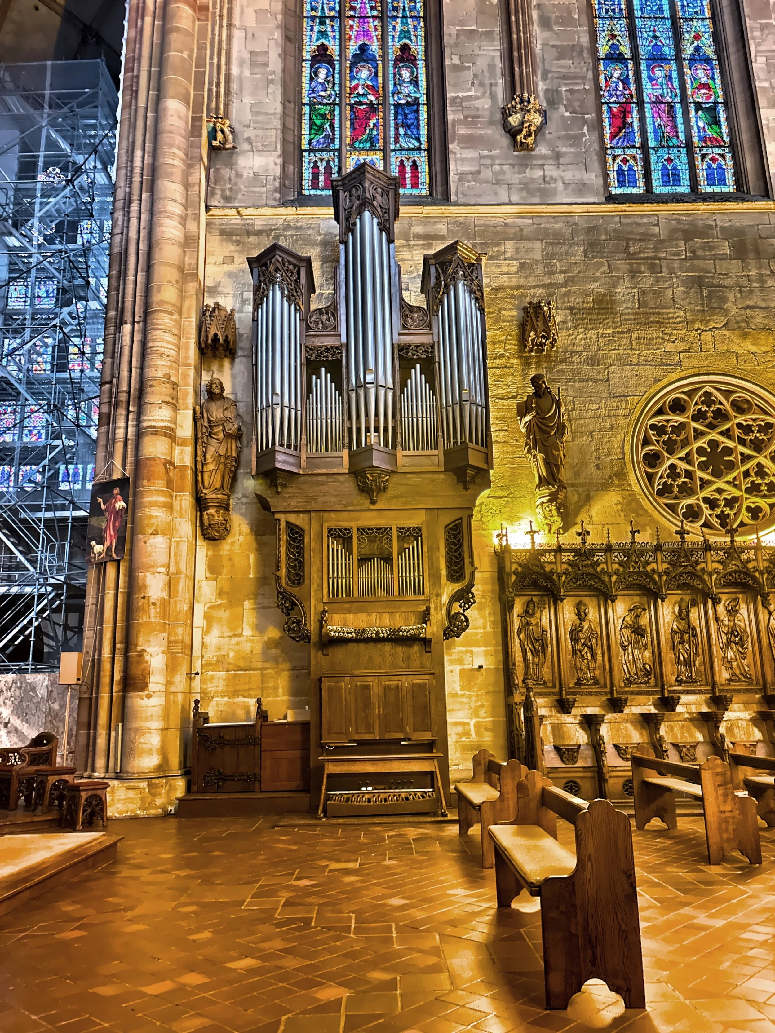  The organ features intricate wood carvings and pipes of varying lengths. 
