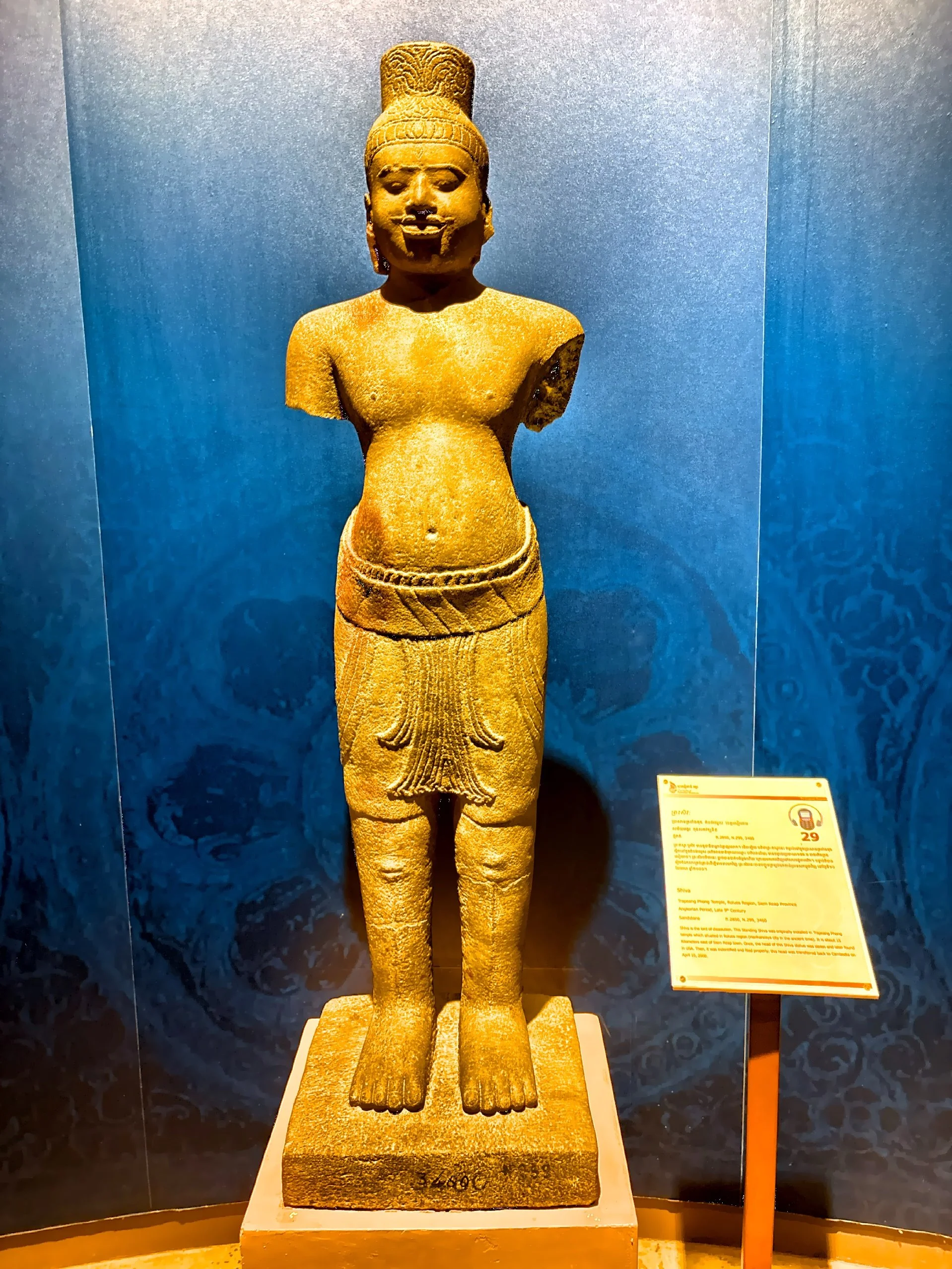  A 9th century sandstone Chiva.  n the 1970s, during Cambodia’s years of turmoil and widespread looting, the statue’s head was stolen — severed from its body and trafficked into the shadowy international art market. 