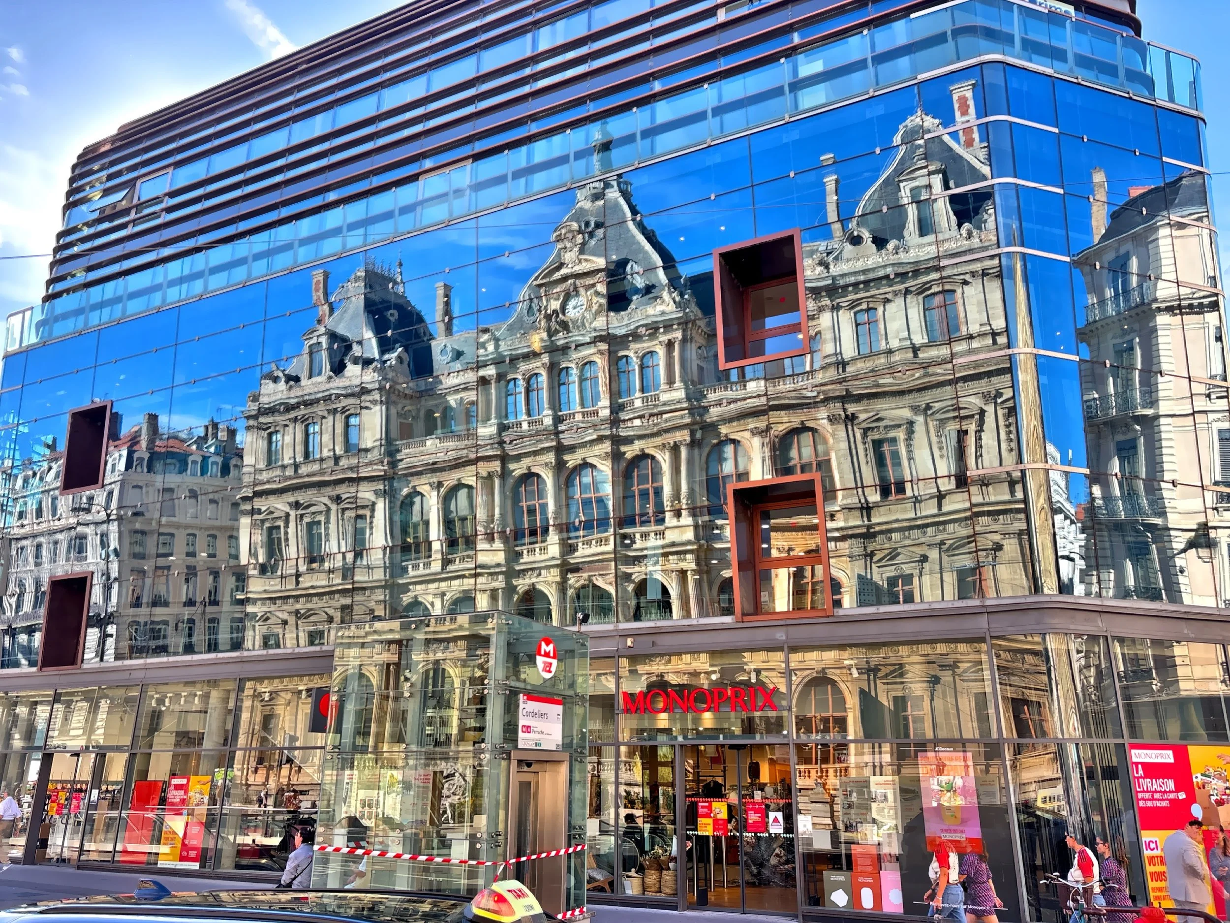  The striking architectural contrast between a modern glass facade and the reflection of the historic Palais de la Bourse. 