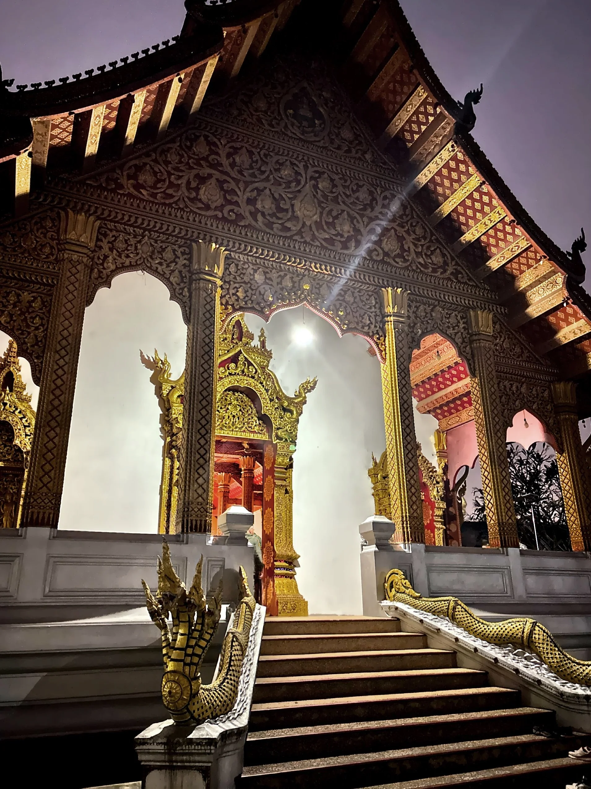  The temple showcases traditional Lao design with a distinctive three-tier, Bangkok-style roof and opulent wooden structure adorned with intricate gold carvings. 