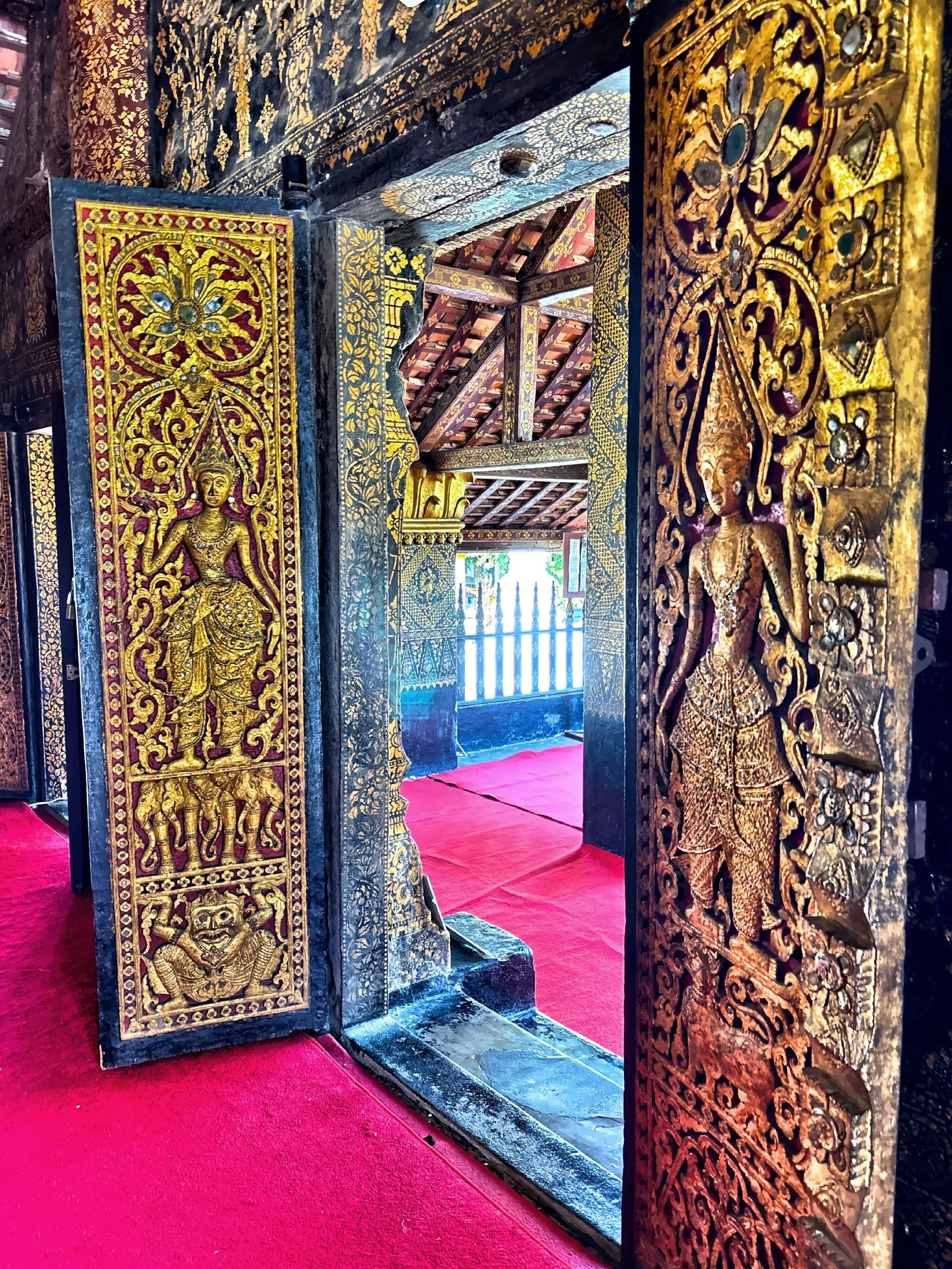  The doors and doorframes feature detailed golden carvings and gilded lacquer work, a distinctive style of the region. 