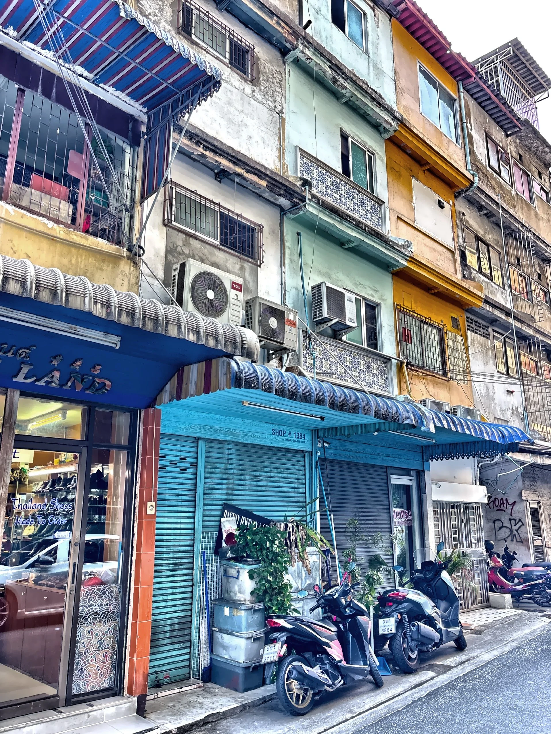  This street scene captures traditional shop houses featuring ground-floor commercial space with upper-level living quarters. 