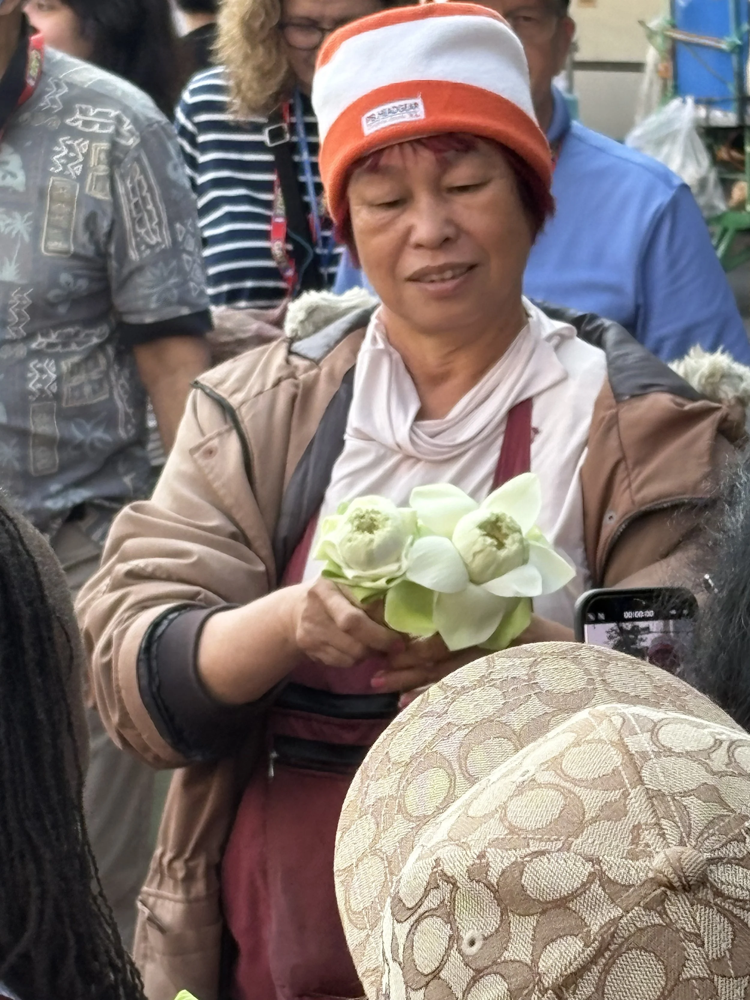  Lotus flowers—equally revered—are carefully prepared for devotion,  symbolizing purity, rebirth, and the teachings of Buddhism, they are often hand-folded into elegant shapes that resemble a blooming bud before being presented in prayer. 
