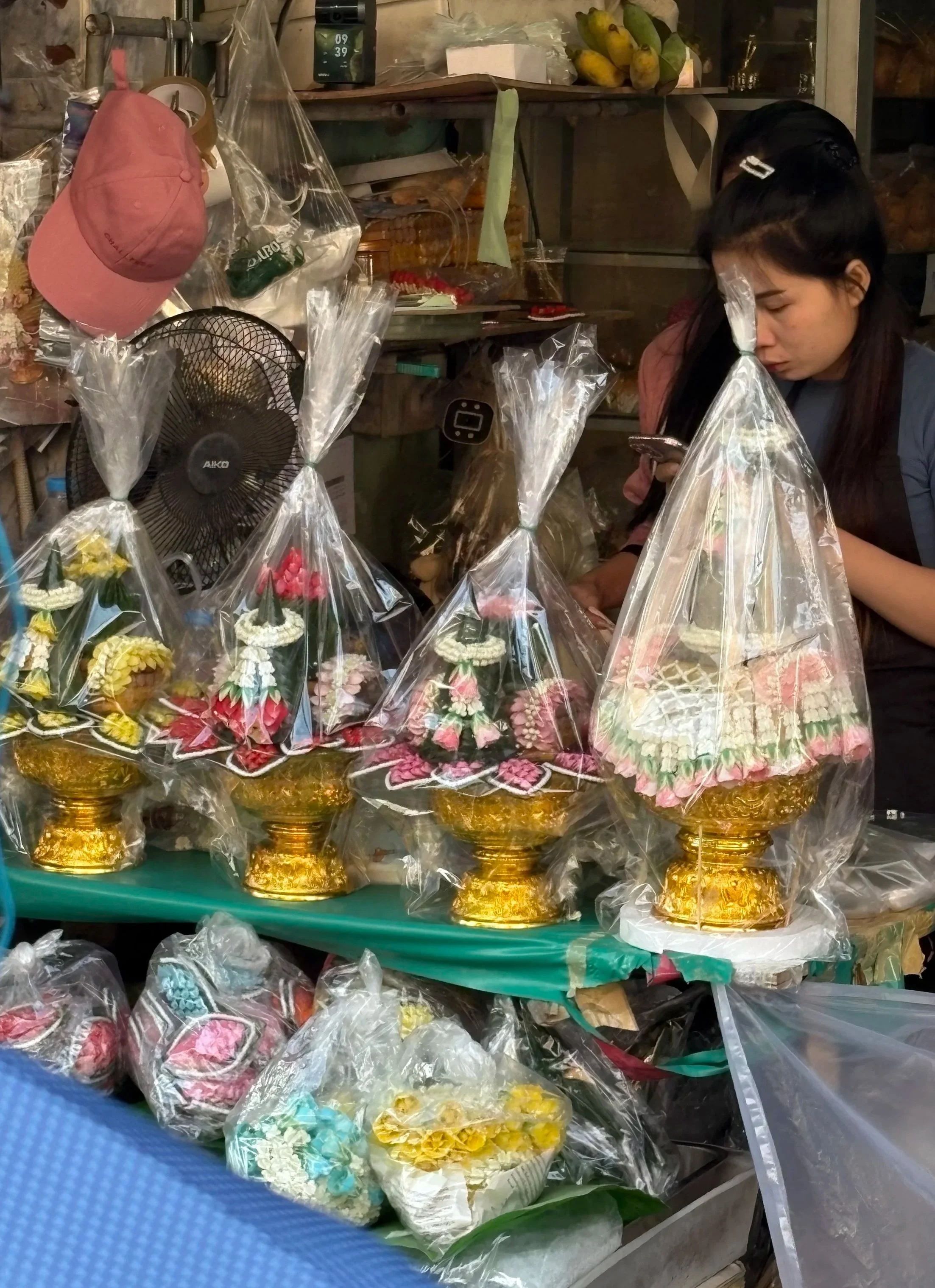 There are rows of pre-made arrangments, meticulously crafted for temples and spirit houses. 