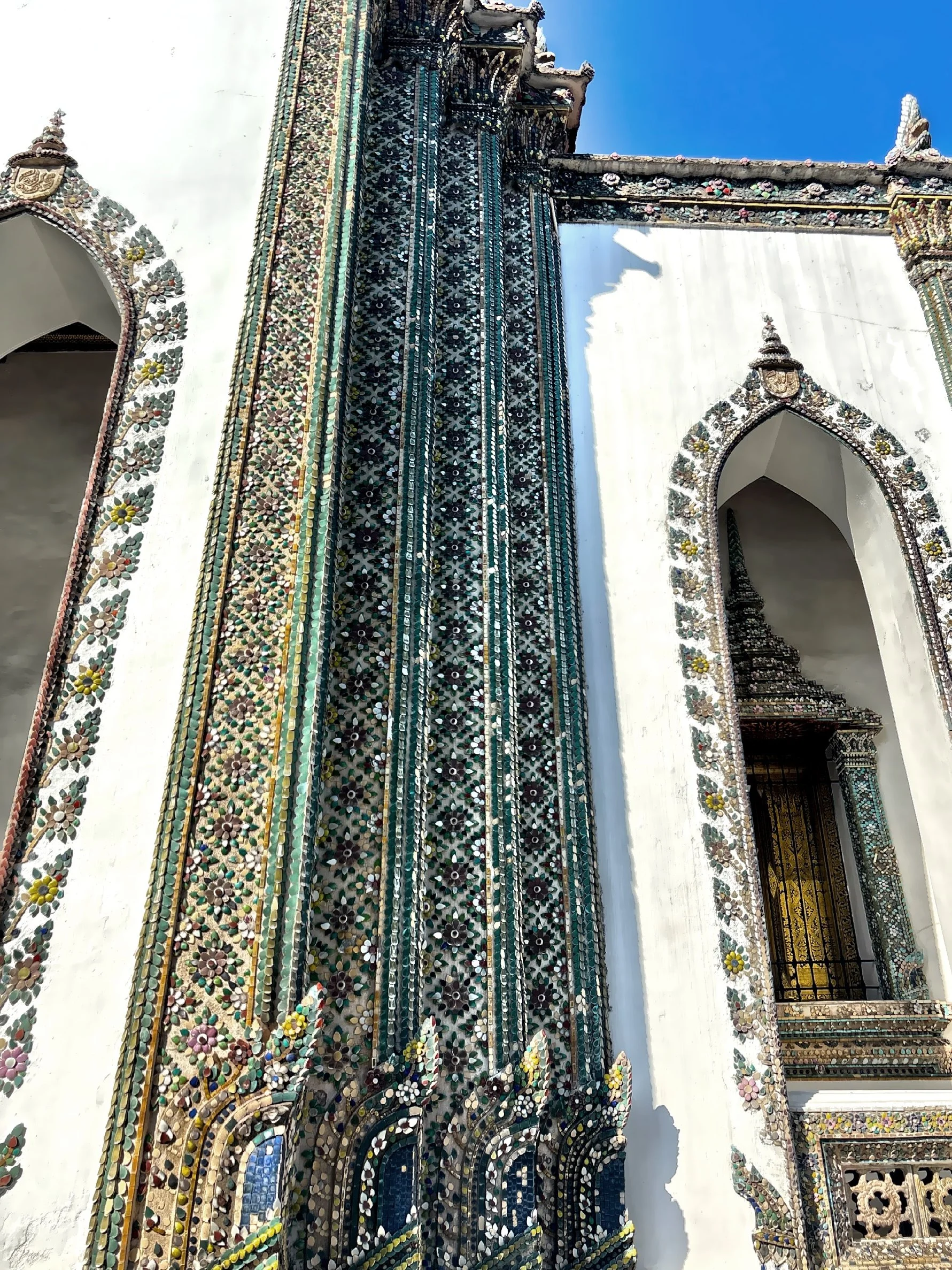  The highly detailed mosaics made of colored glass and porcelain, the hallmark of Thai temple architecture.  