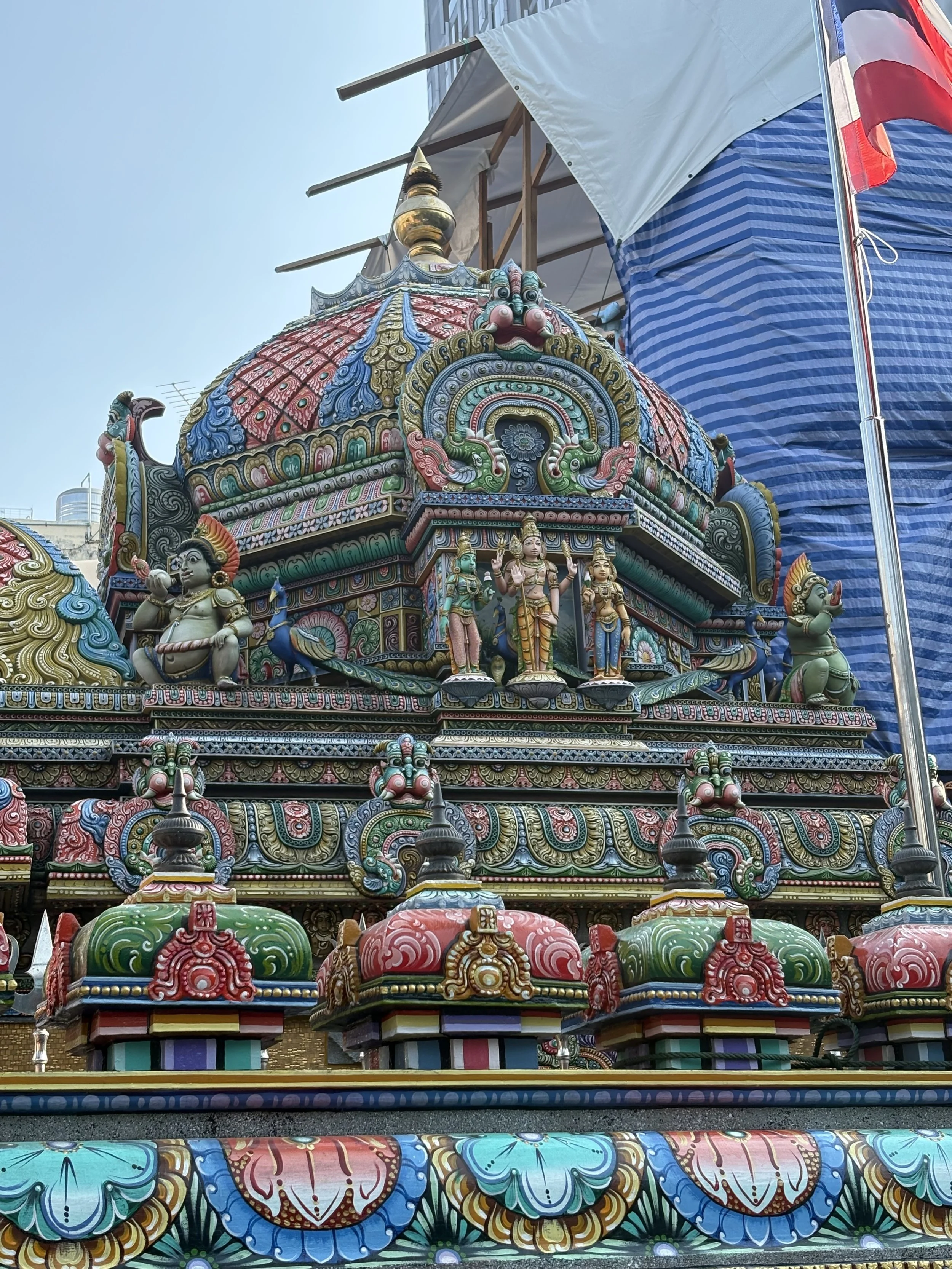 The temple’s facade is adorned with colorful mosaic artwork and intricate carvings that depict a pantheon of Hindu deities. 