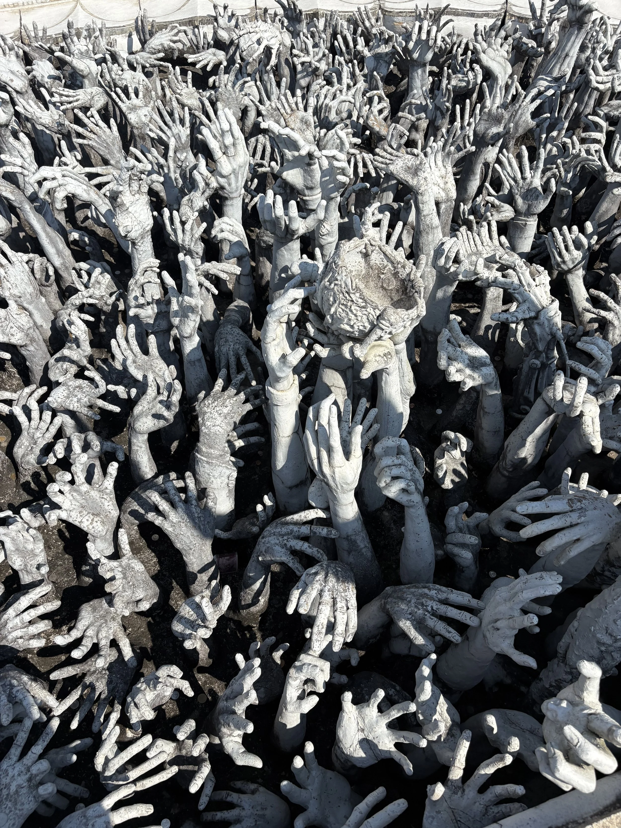  The sea of outstretched hands represents desire and suffering before reaching the main temple. 