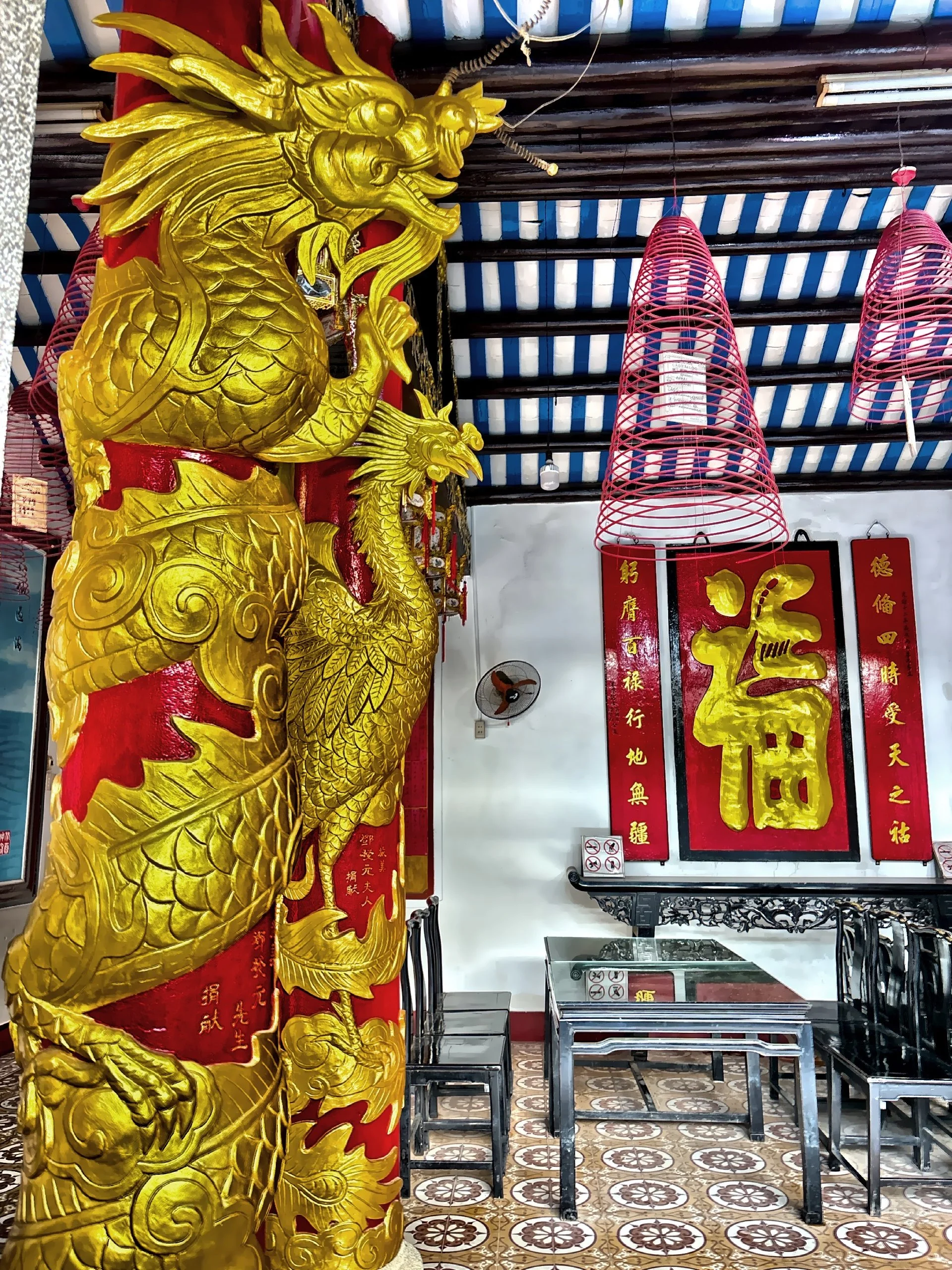  A large intricately carved golden dragon wrapped around a pillar. 