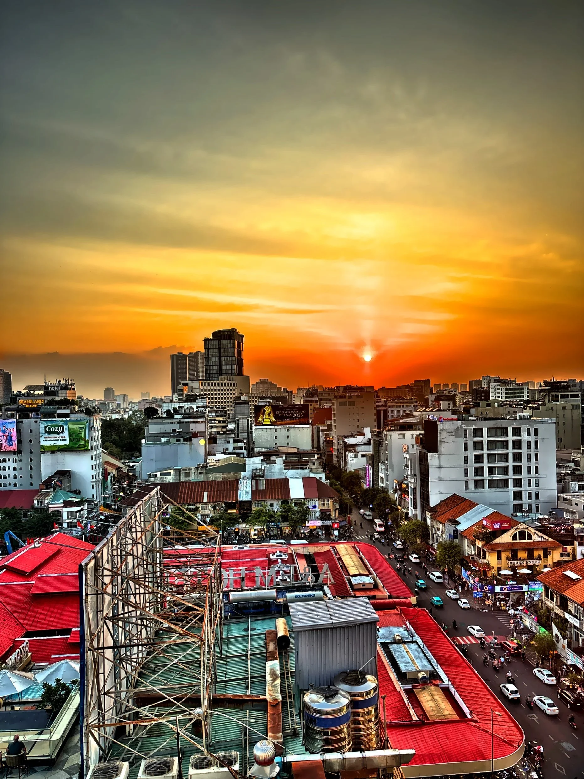 From the rooftop, the city glows in the fading light of sunset. 