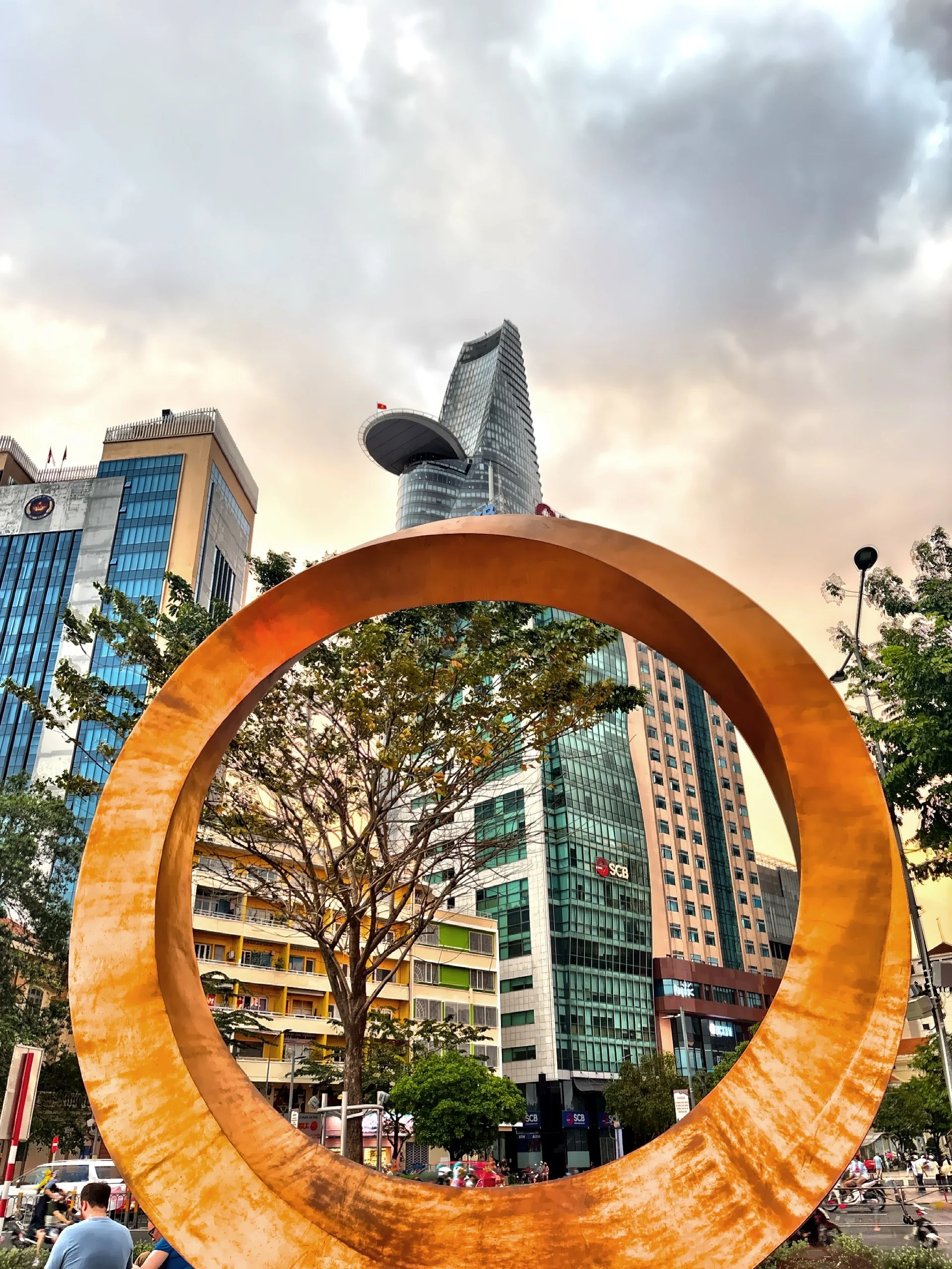  Public art display in a park with the Bitexco Financial Tower, renowned for its distinctive helipad protruding from the 52nd floor. 