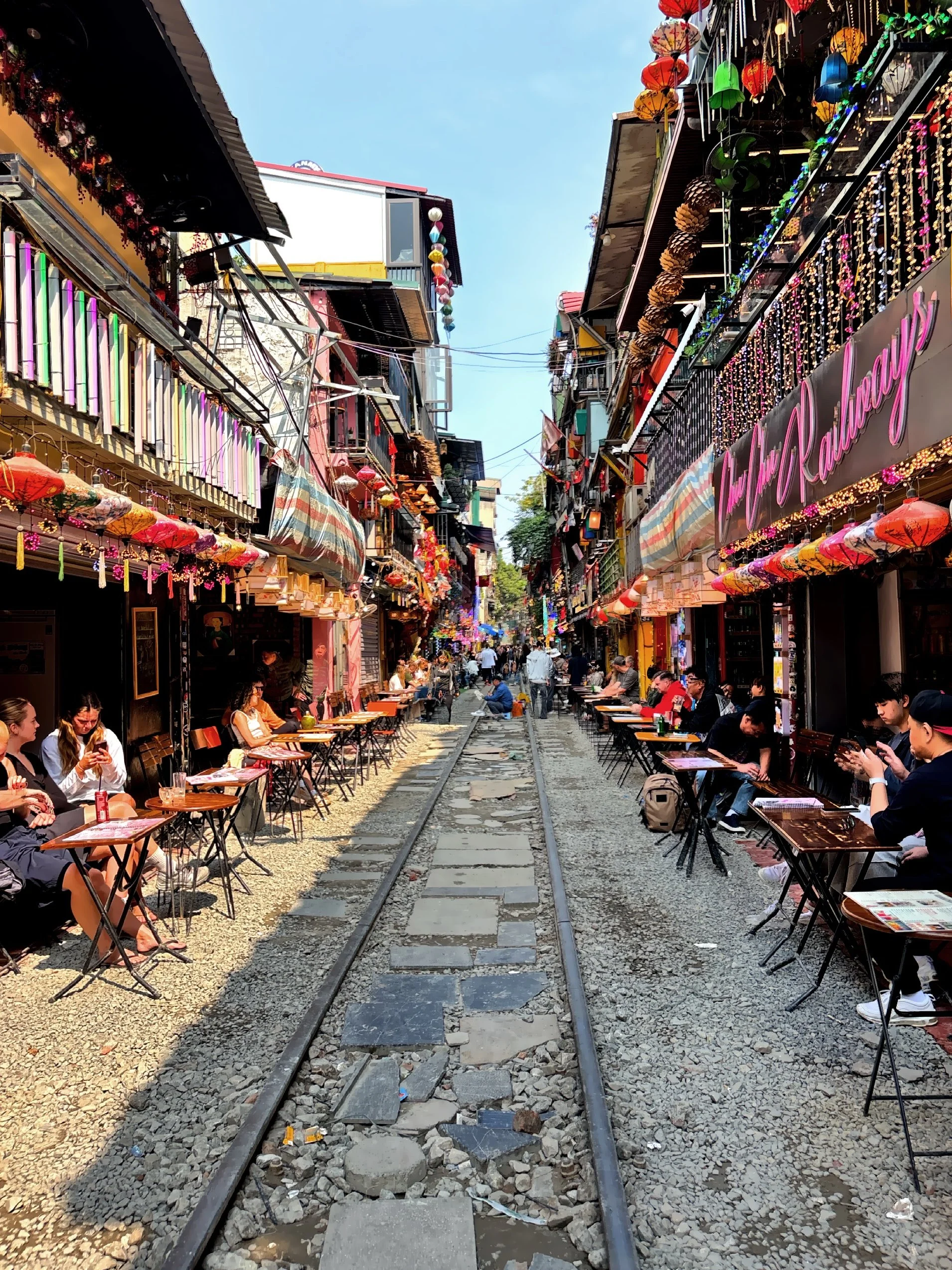 Visitors sit at small cafes right beside the tracks, waiting for the train to pass—just a few feet away. 