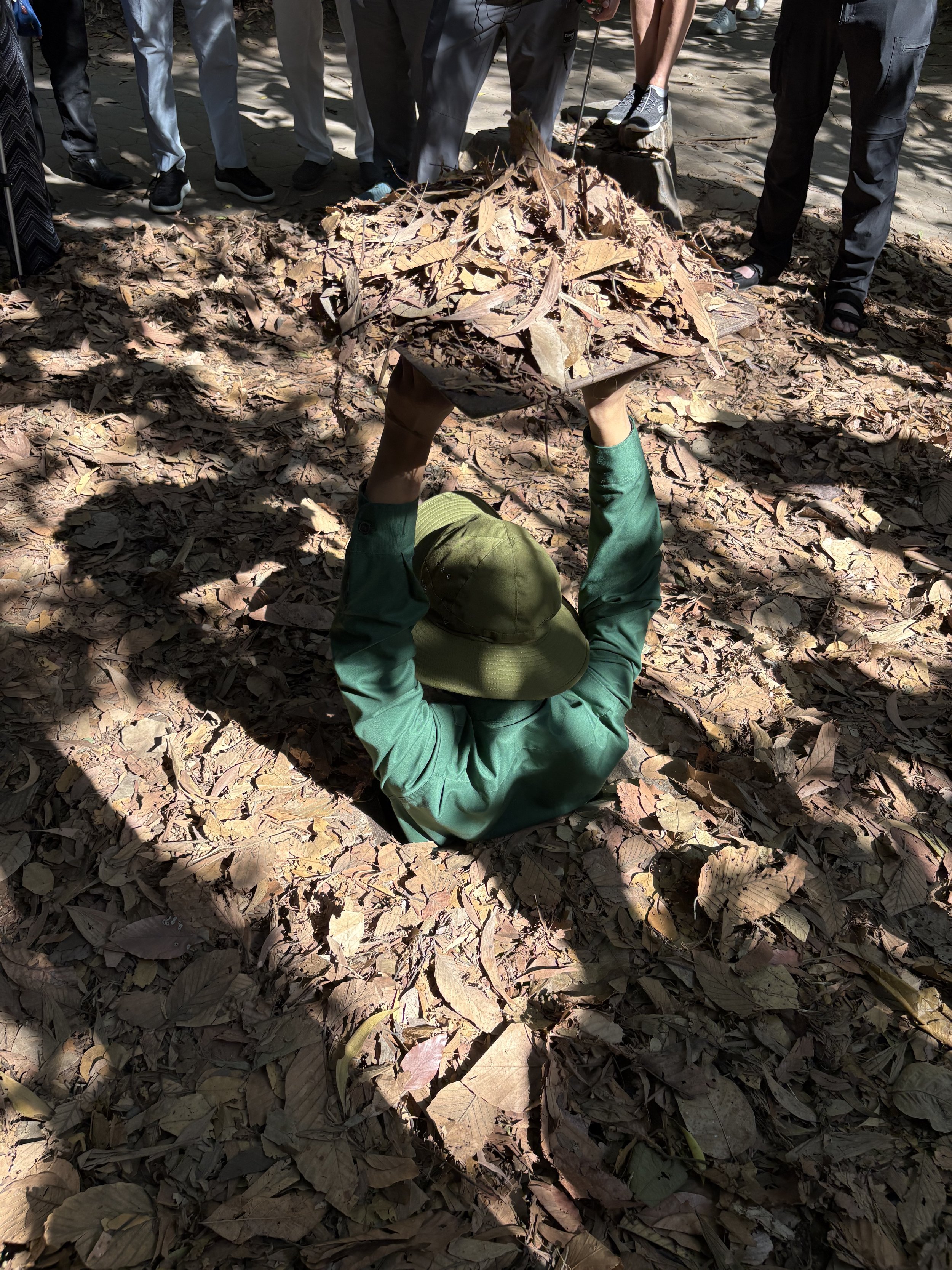  Demonstrating the exit from the tunnels. The tunnels were often disguised with leaf- covered trap doors to blend seamlessly into the jungle floor. 