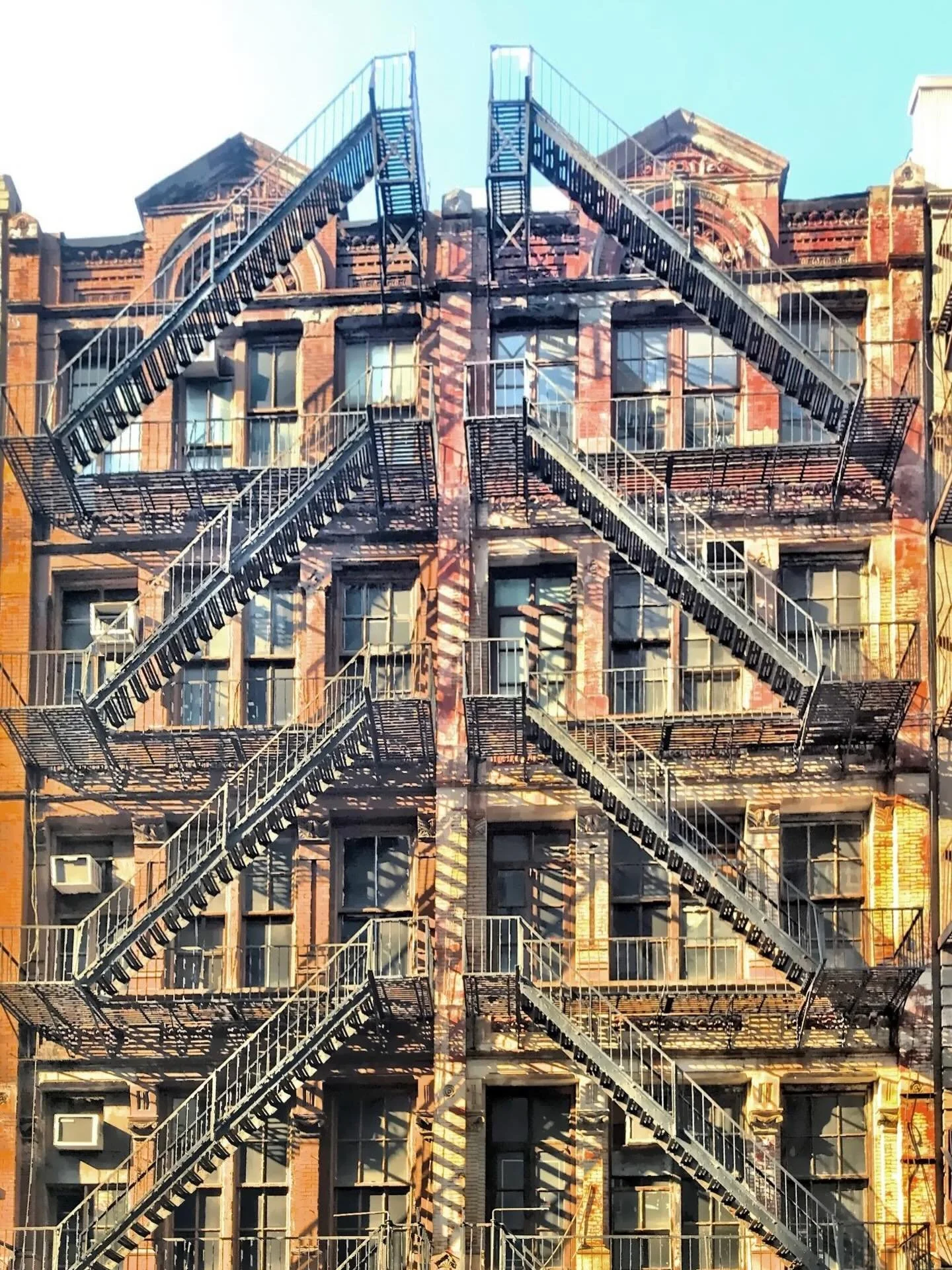 Fire escapes, lower east side of Manhattan. While designed for emergency egress, these structures have historically served as makeshift balconies or social spaces for residents. #lowereastsidenyc #fireescapes #buildingfacades #nyc  Check out my blog: