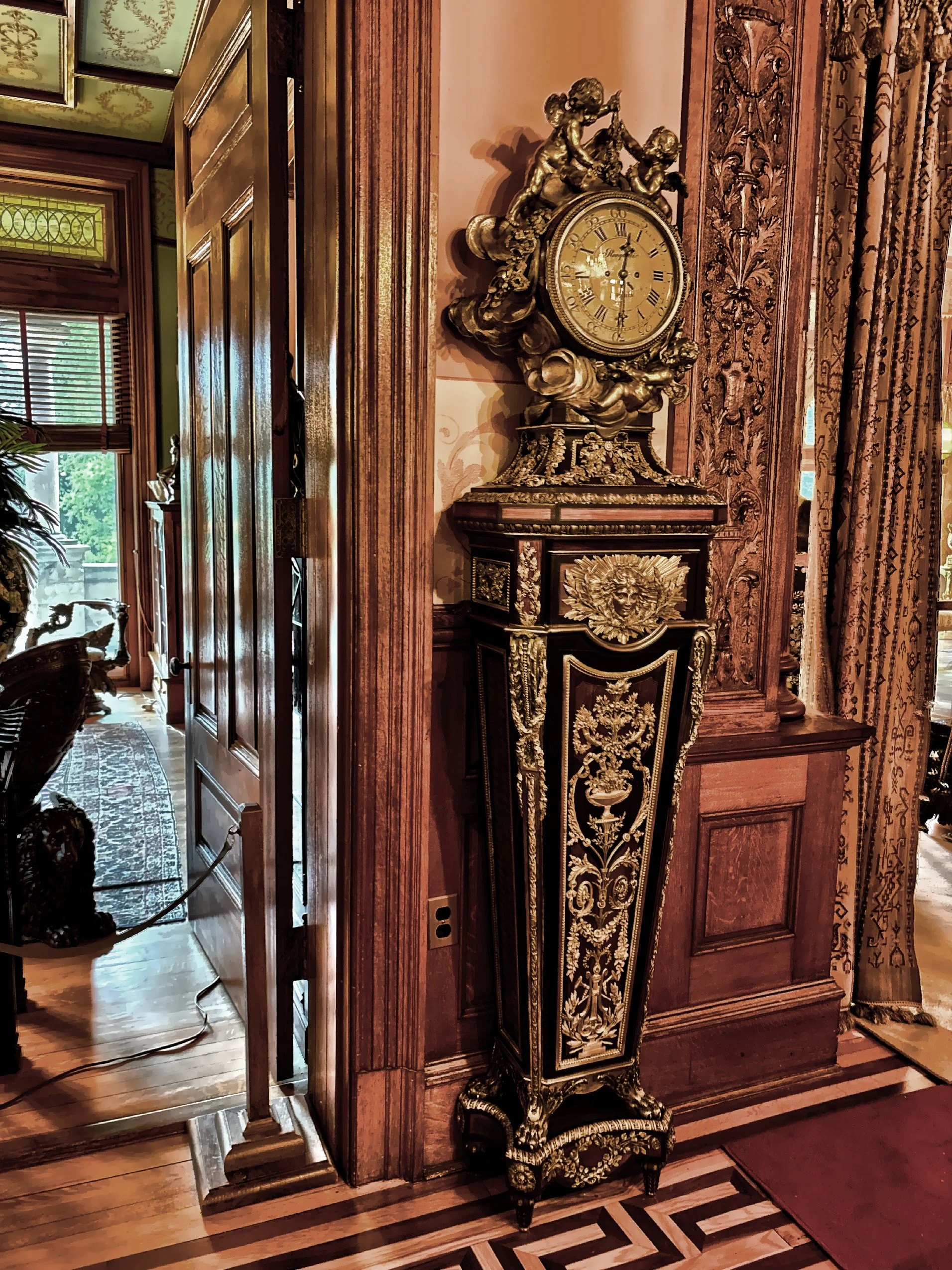  French Louis XVI style ormolu-mounted tall case clock featuring intricate brass inlay and gilded bronze. 