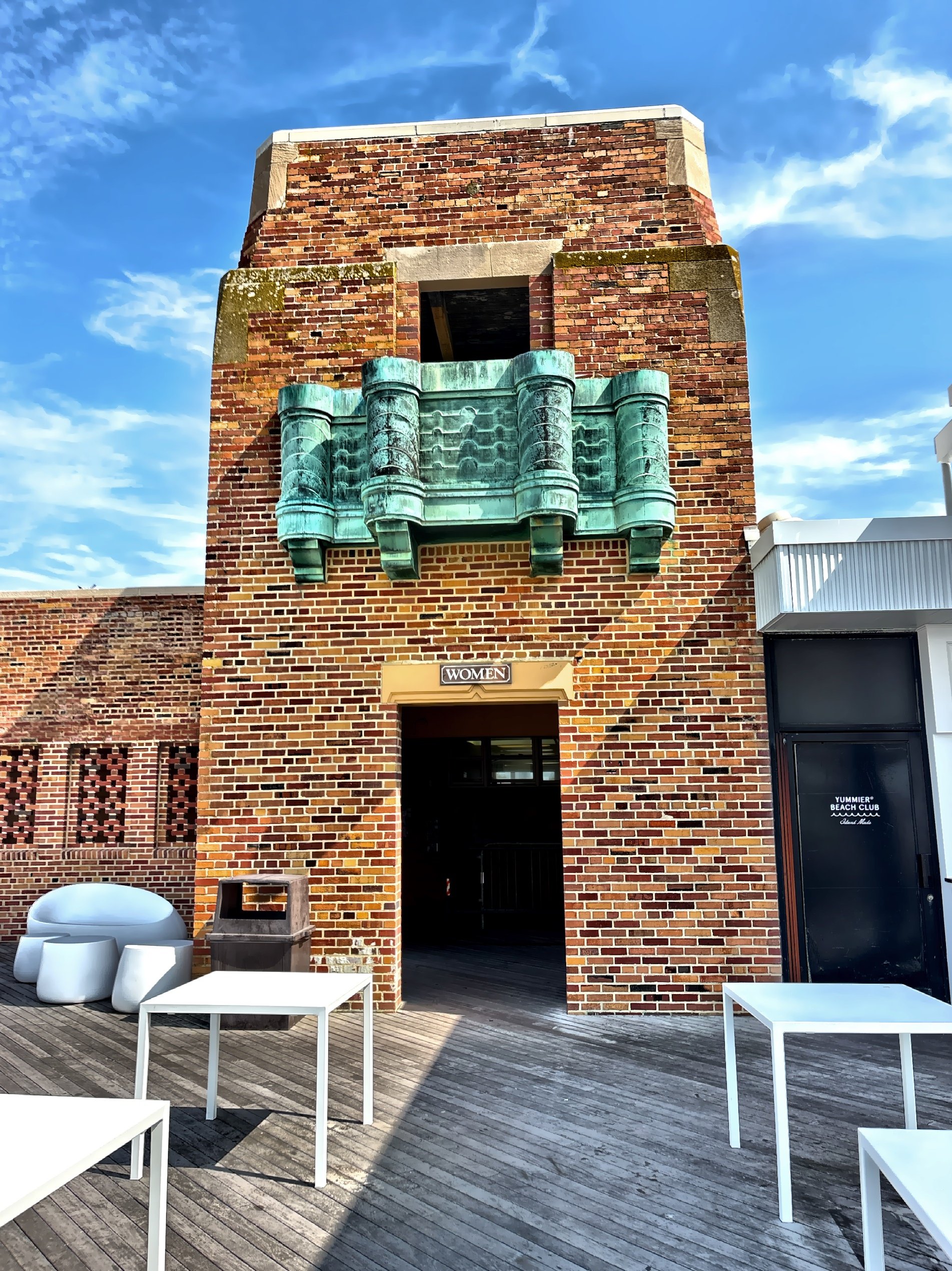 A section of the West Bathhouse showcases its distinctive multi-hued Barbizon brick façade and green-patina copper balcony. Constructed between 1930 and 1931, the building is one of Jones Beach's most recognizable examples of Art Deco architecture. 