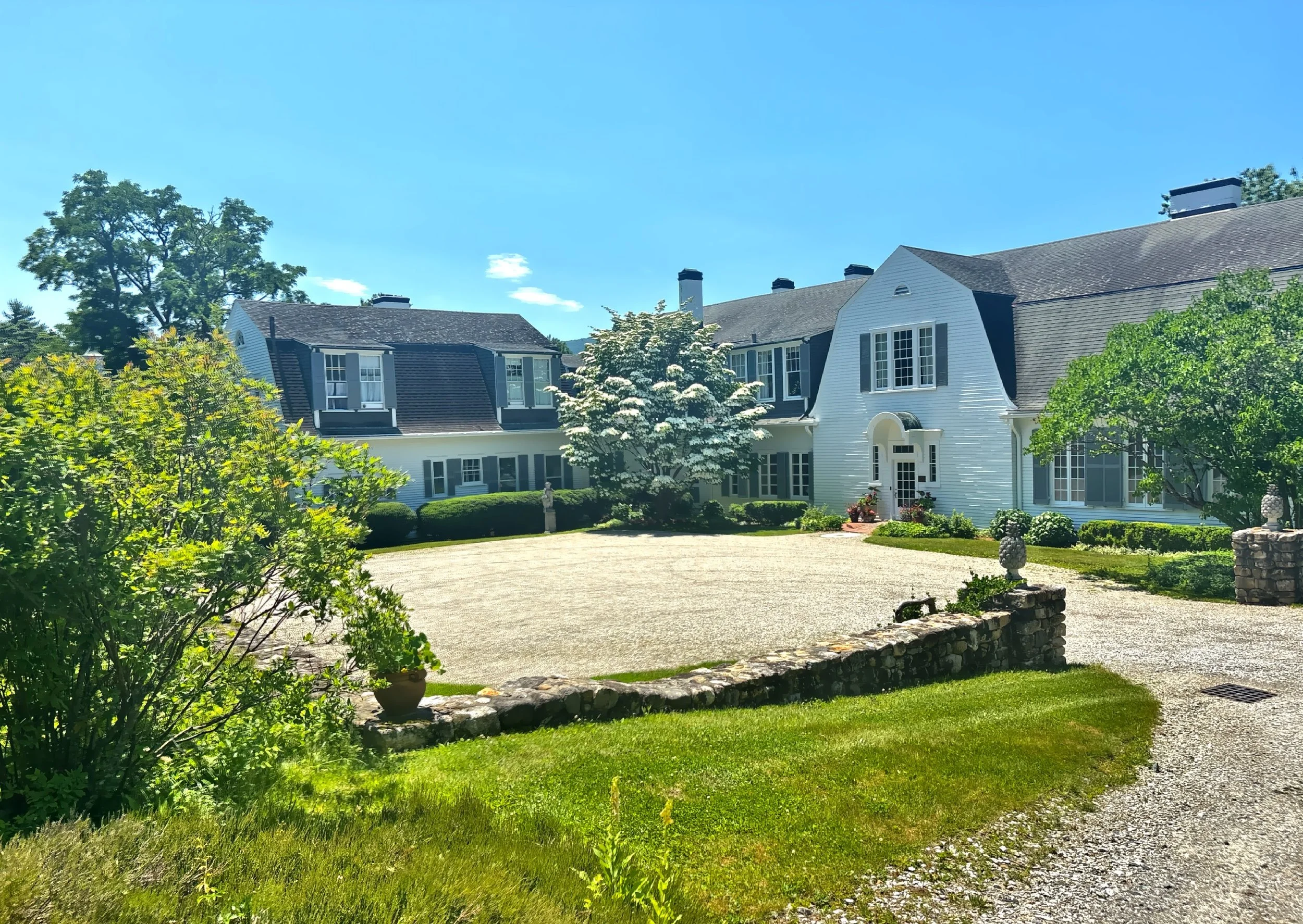  At the heart of the estate stands the Colonial Revival main house, its distinctive gambrel roof serving as one of its defining architectural features. 