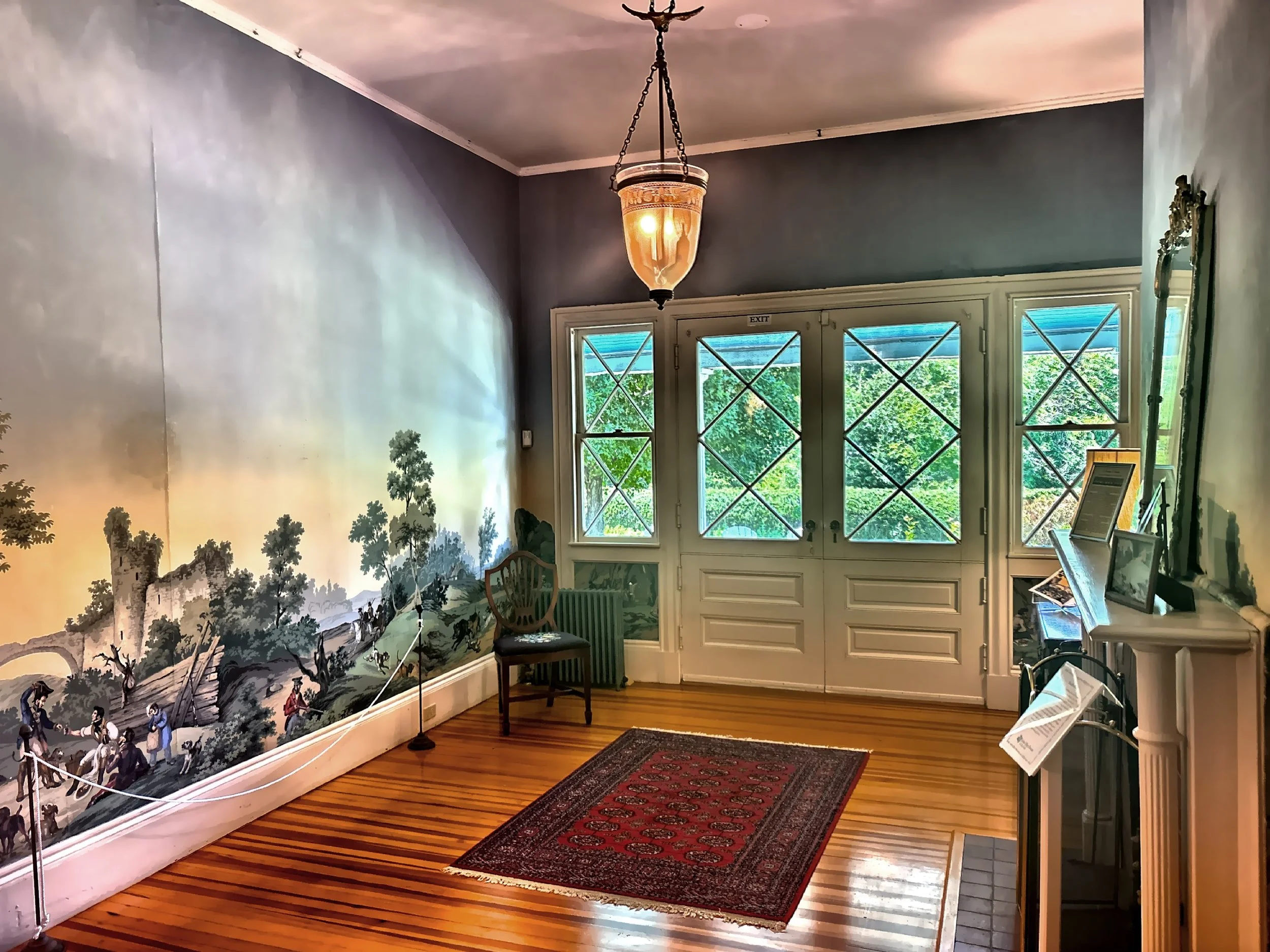  The original main cottage entrance hall with staircase features panoramic wallpaper. 