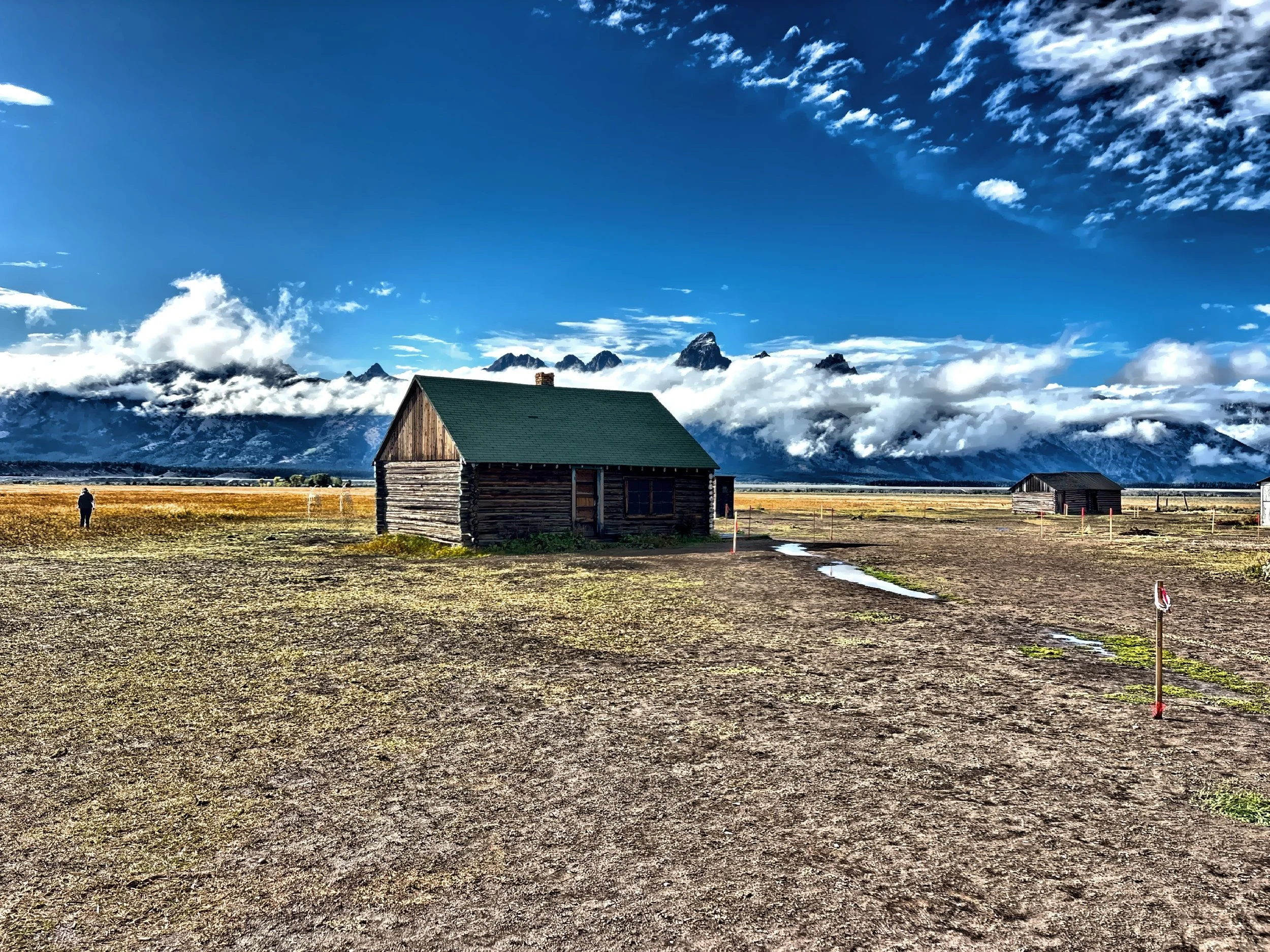  The weathered timber structures seem almost impossibly small beneath the mountains. 