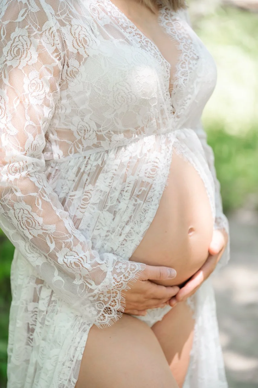 Pregnant mother wearing a white lace duster jacket during her maternity photography session in Baltimore, MD