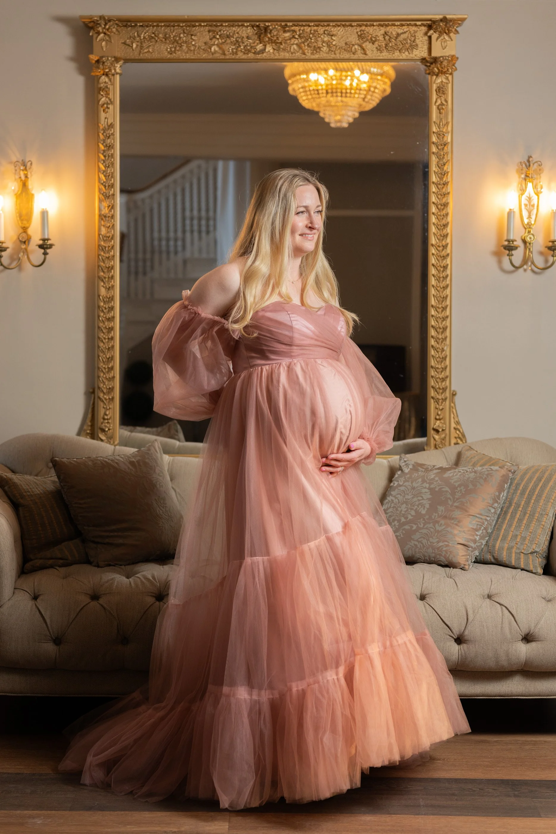 An expectant parent in a rose pink tulle gown during a moody, fine-art on-location maternity photography session in Maryland.