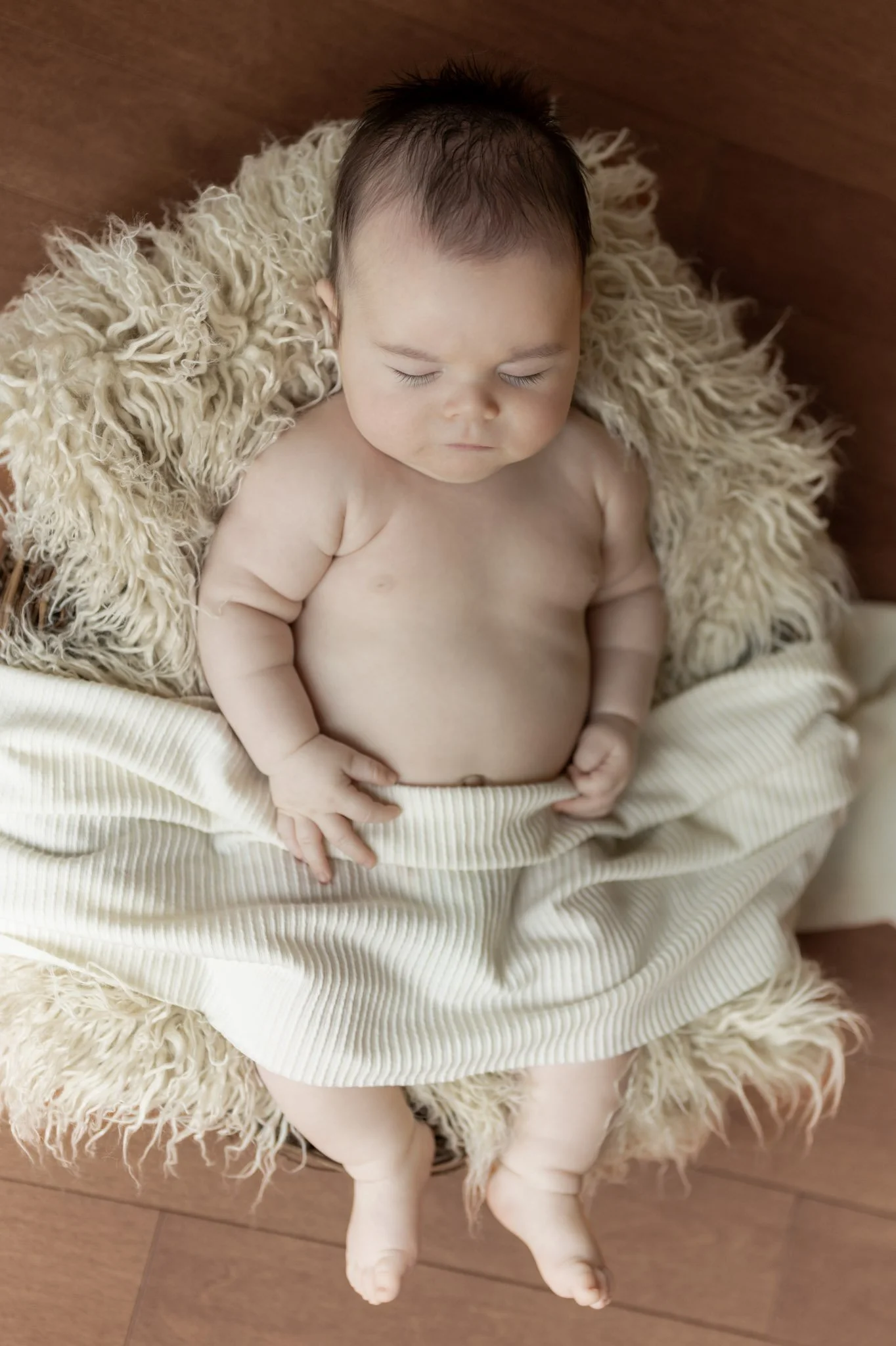 A newborn baby sleeping in a prop nest during his Maryland newborn photography session