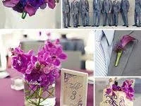 A collection of flowers including pink orchids and purple irises, with a greeting card and a row of what appears to be game controllers or similar items in the background.