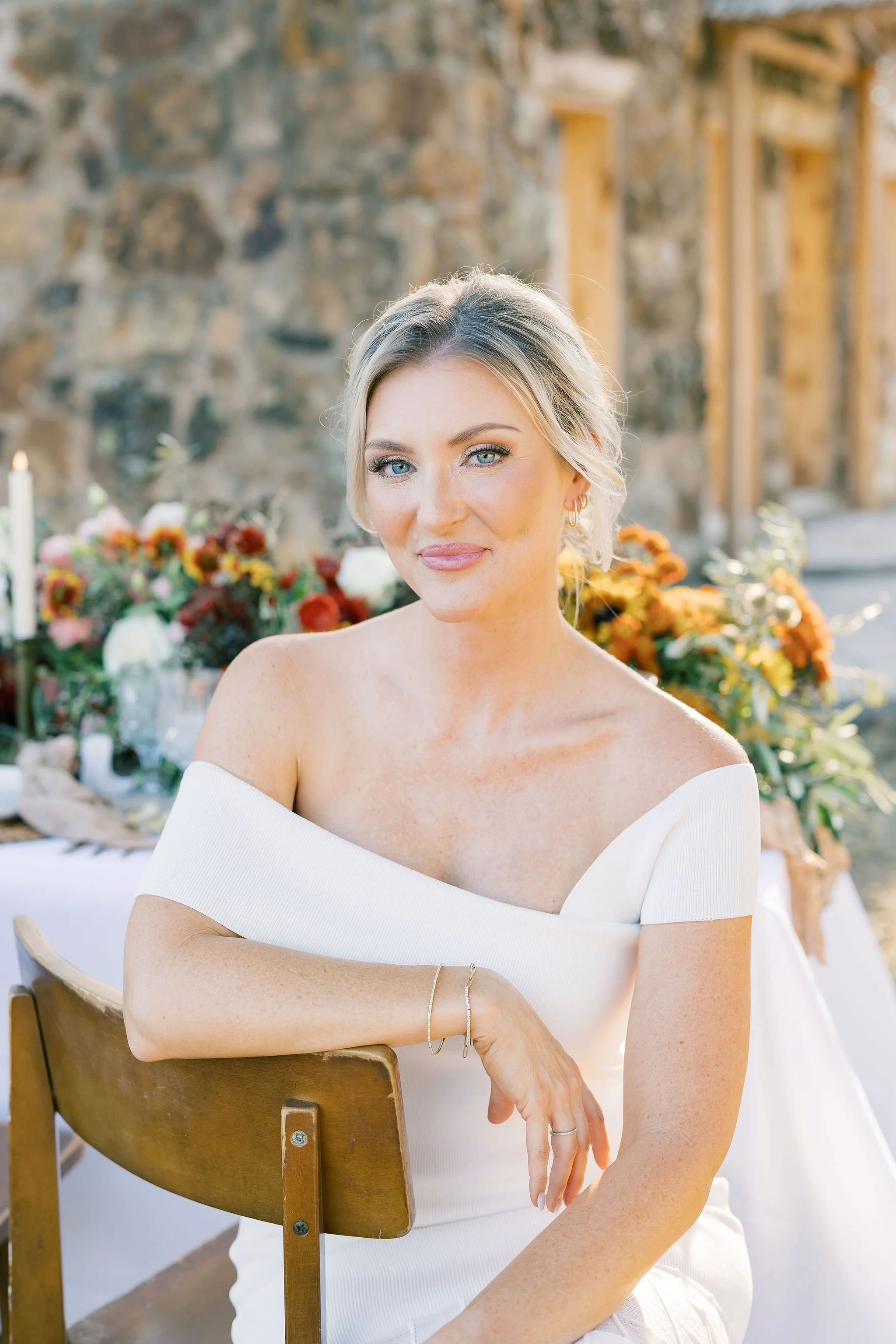 Elegant bride smiles at camera in front of the luxury banquet wedding table
