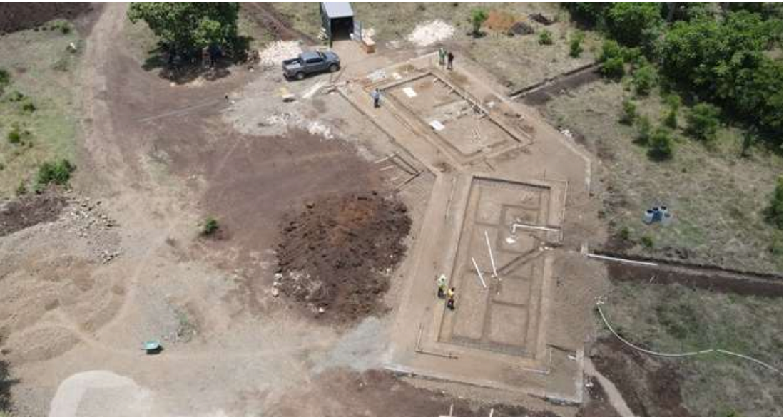 The building pad at final elevation, trenching for the foundation. In addition, the sanitary sewer and gray water infrastructure was installed at this time.