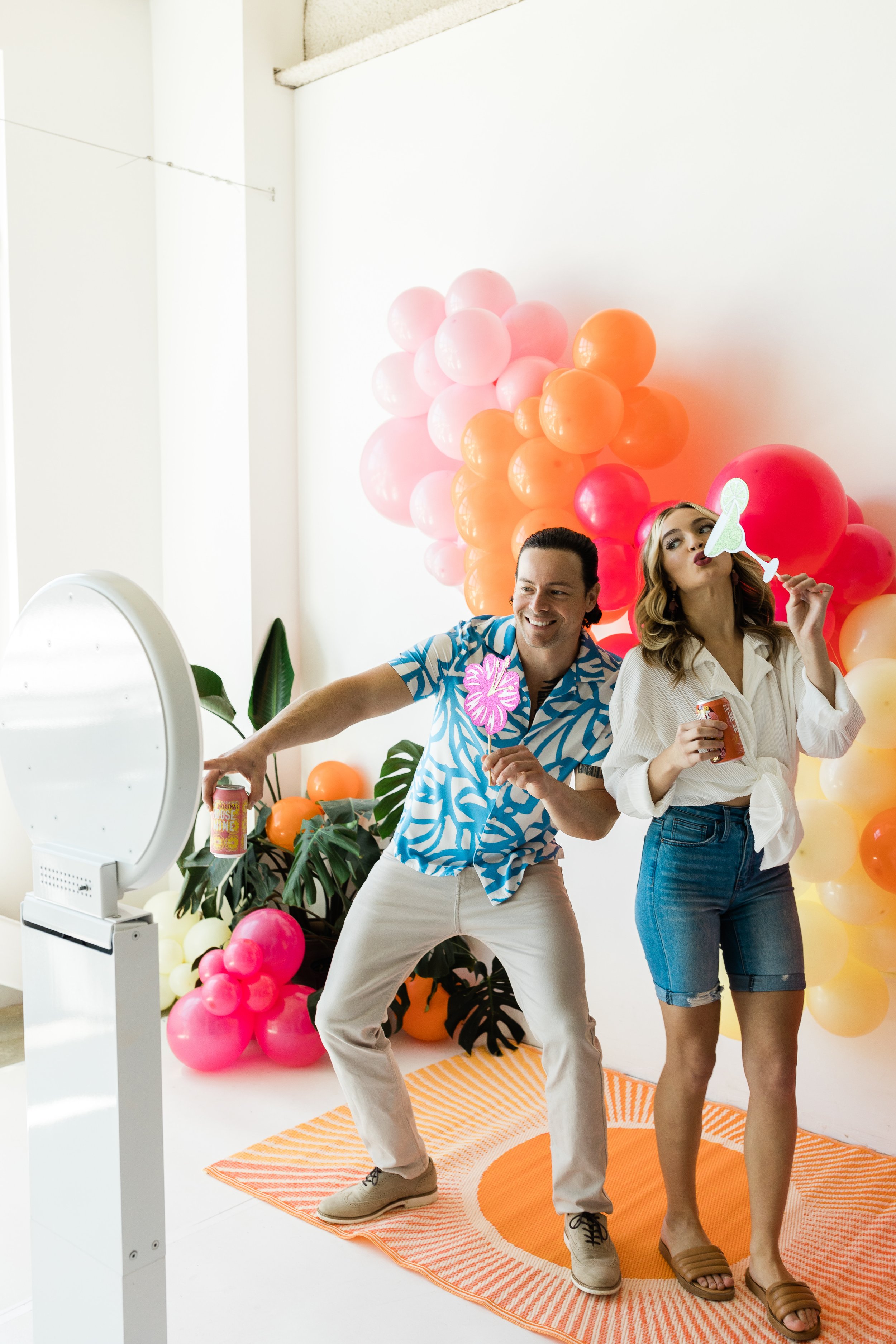 Couple posing in front of a digital photo booth with props