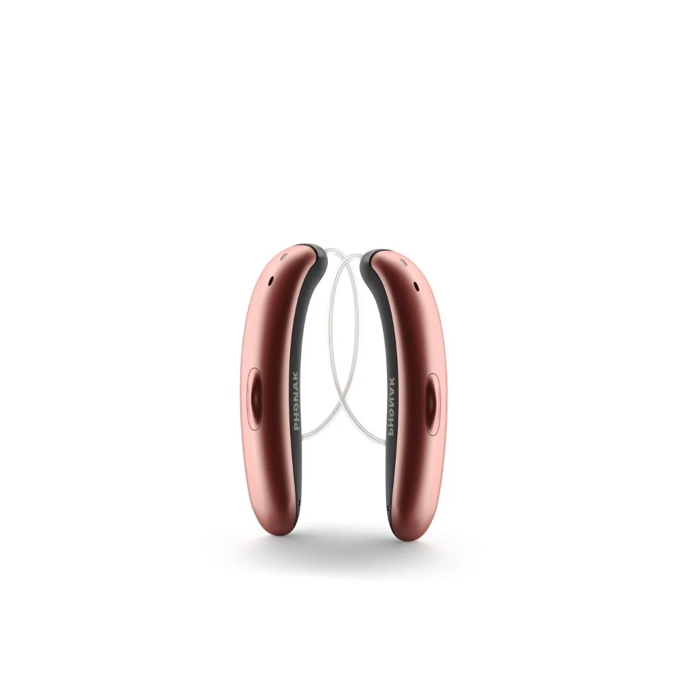 Pink and black hearing aids facing each other against a white background.
