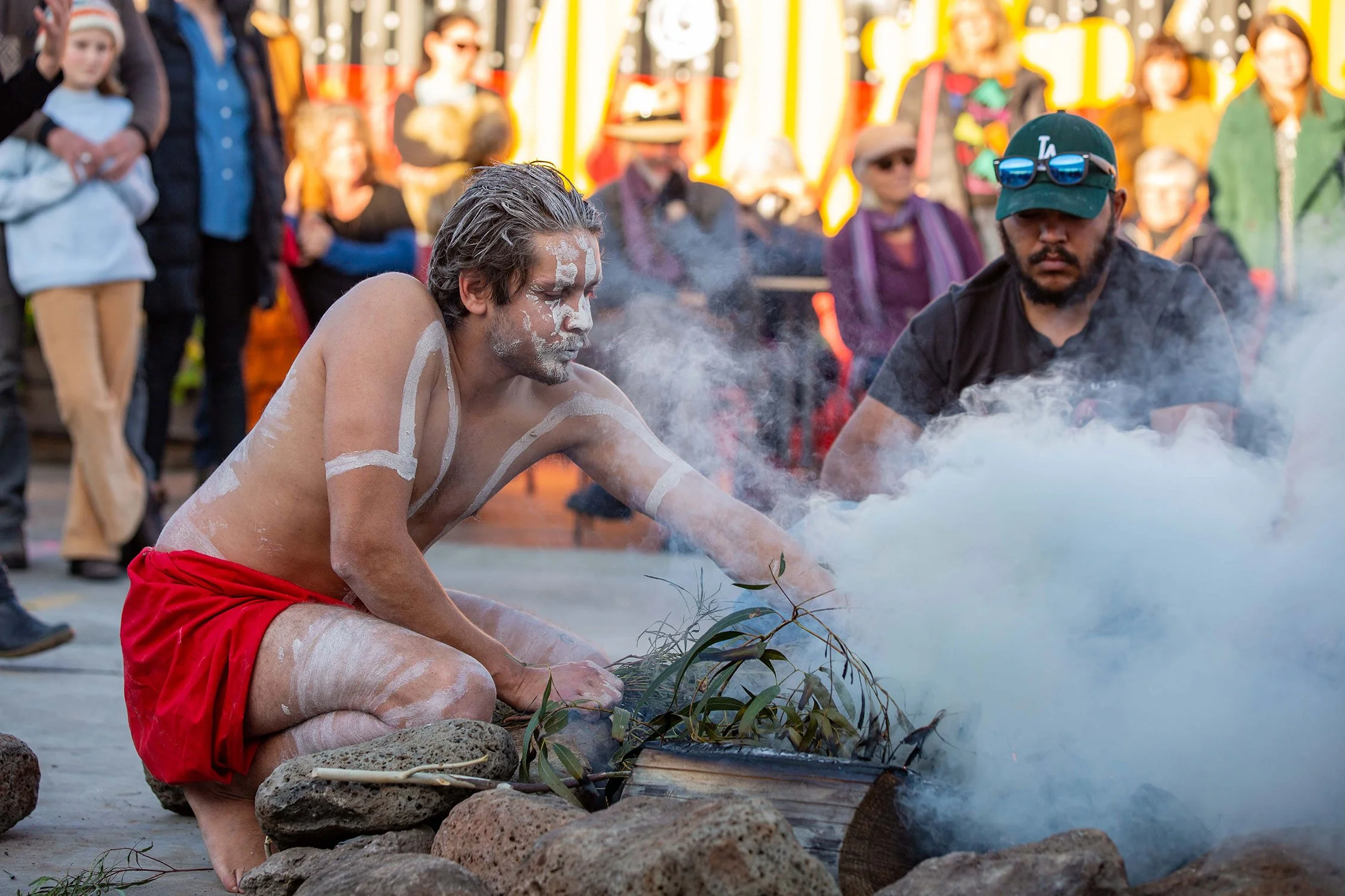 Two Indigenous men performing smoking ceremony