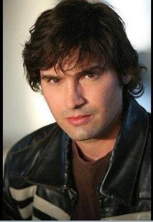 Portrait of a person with dark hair wearing a leather jacket.