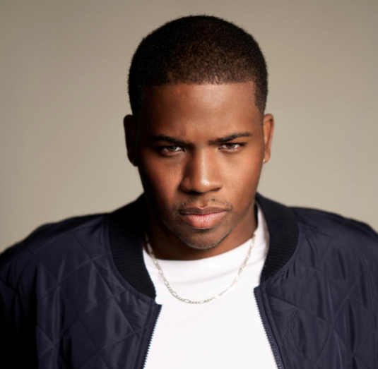 Man in a blue jacket and white shirt looking directly at the camera.