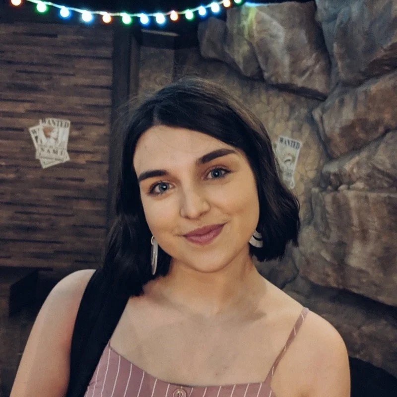 Woman smiling indoors with string lights and rustic background