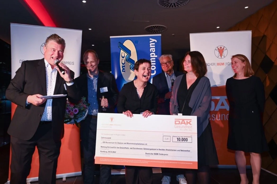 Bettina and Constanze holding a prize check for 10000 Euro from the DAK for their pioneering work.