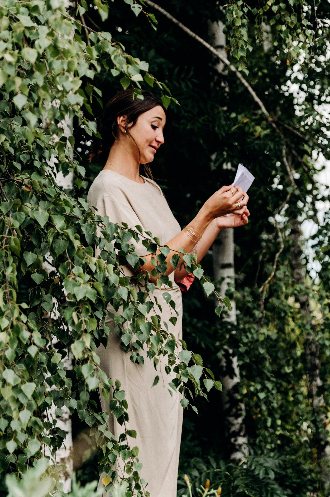 Femme lisant une lettre dans un jardin verdoyant.