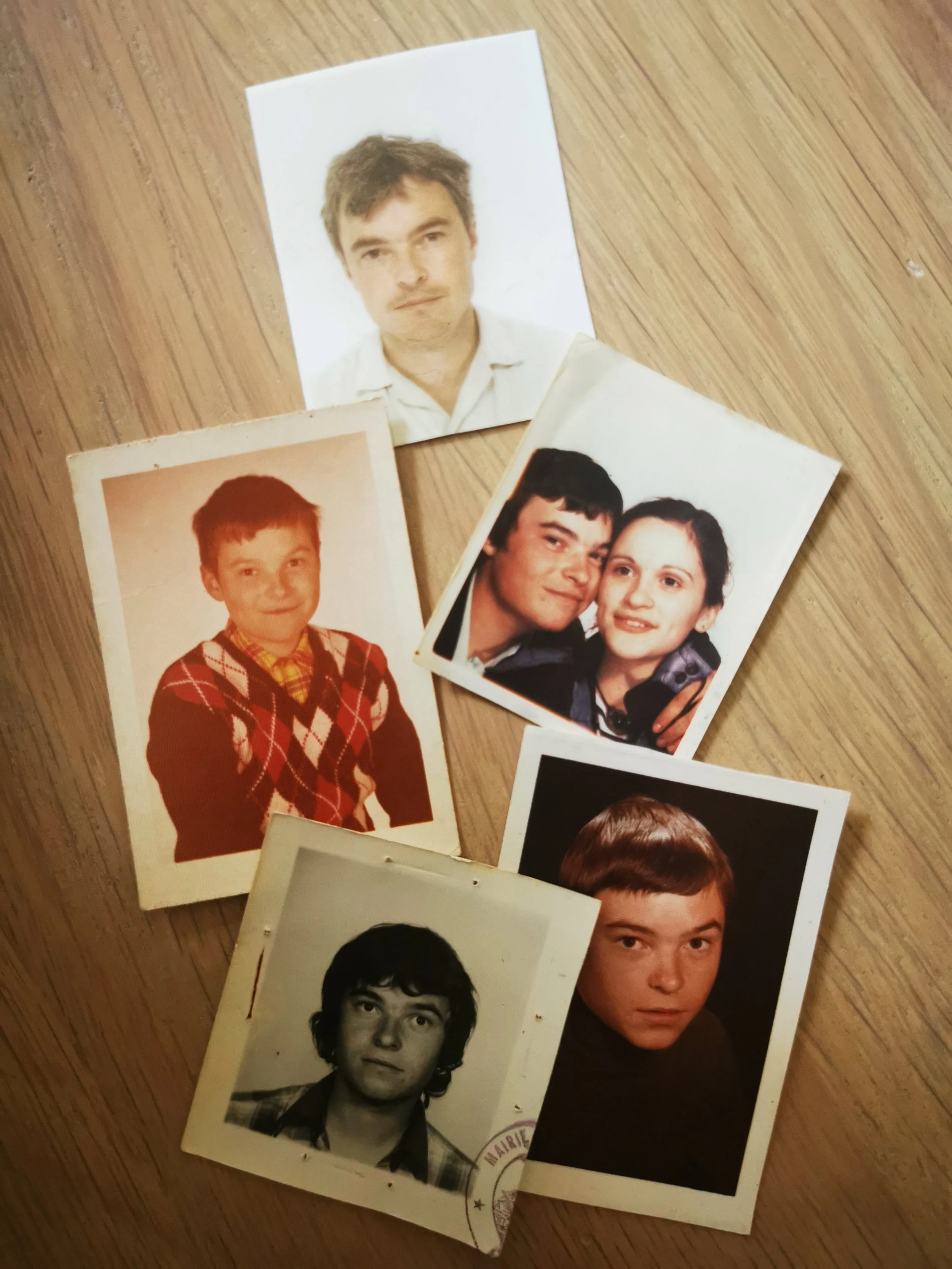 Un ensemble de cinq photos vintage montrant des portraits de personnes sur une surface en bois. Les images incluent des photos en couleur et en noir et blanc.